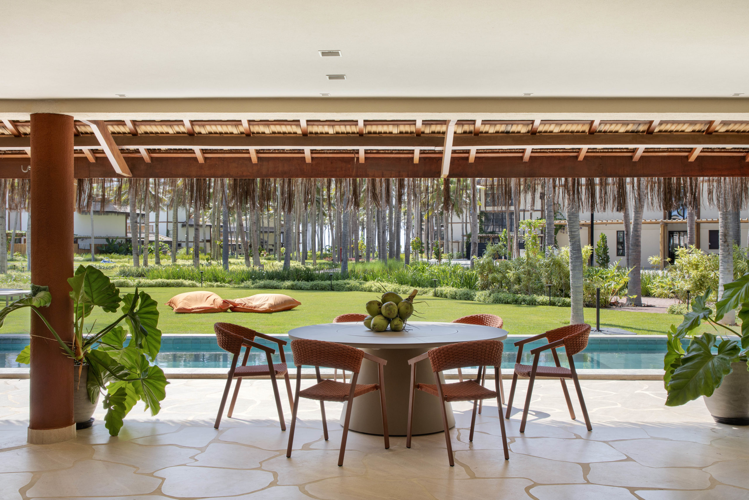 na foto varanda de casa de praia de frente para a piscina com mesa para 6 pessoas