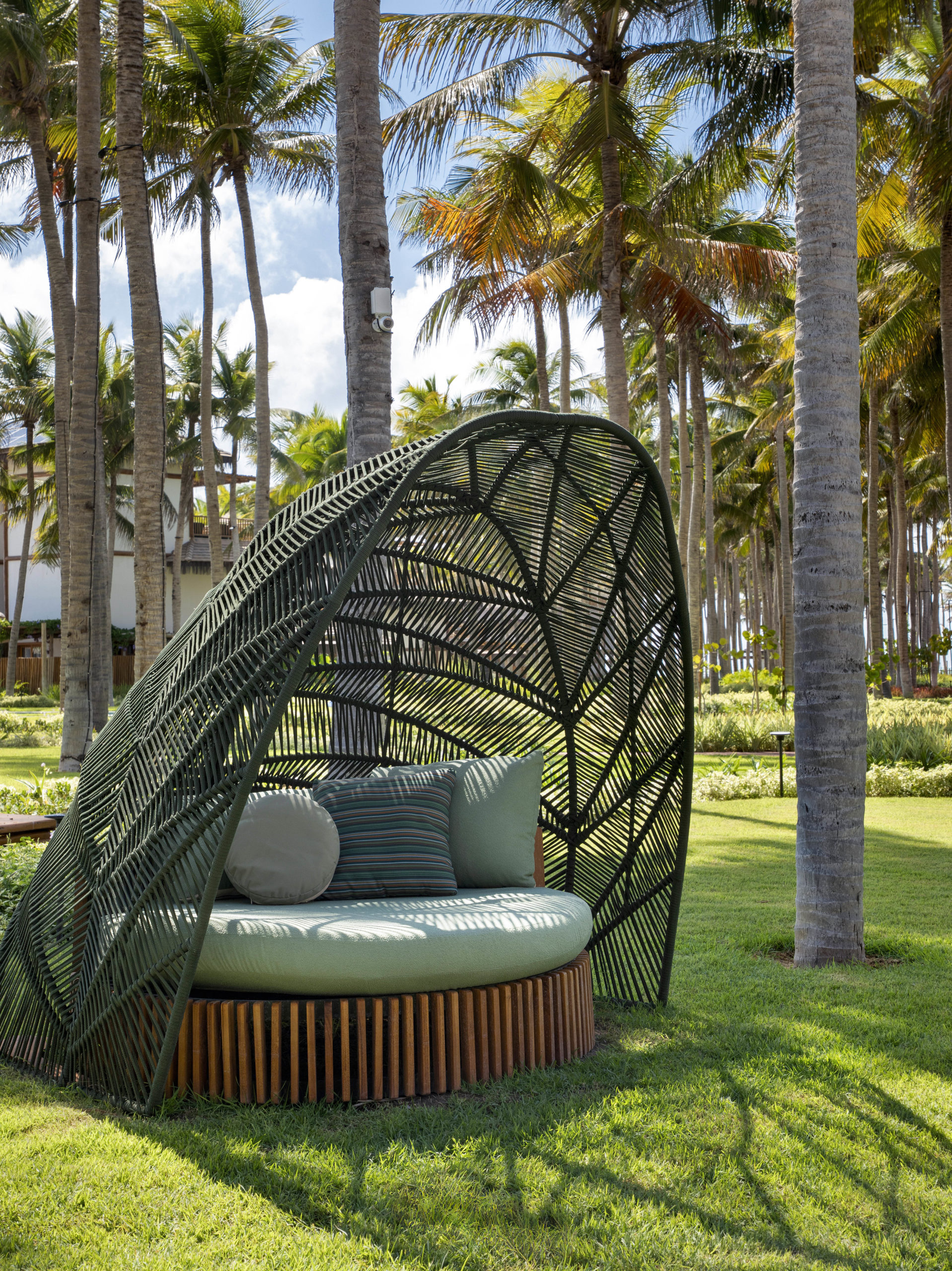 na foto cadeira verde em jardim de casa de praia