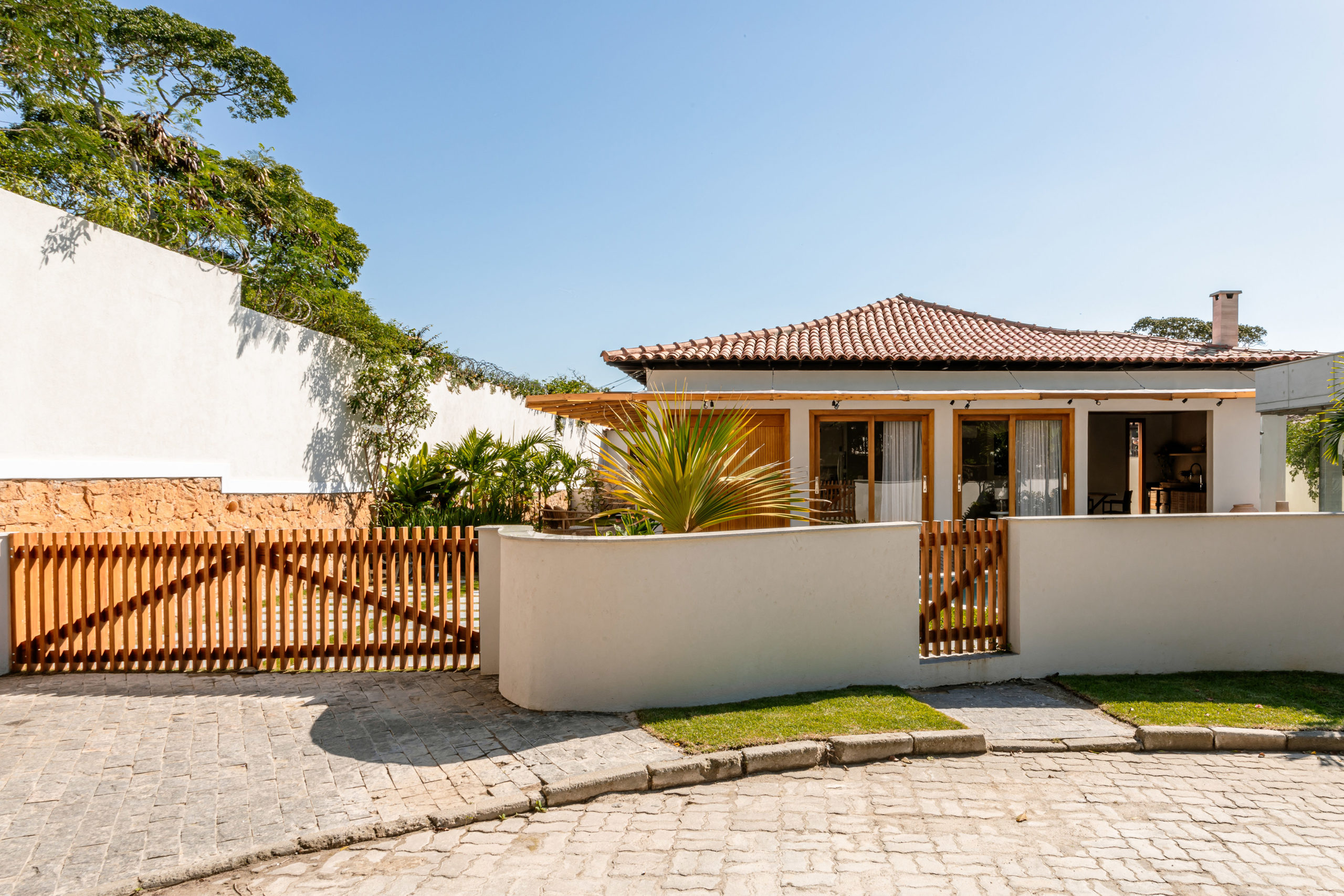 na foto entrada de casa com esquadrias de correr em madeira e vidro
