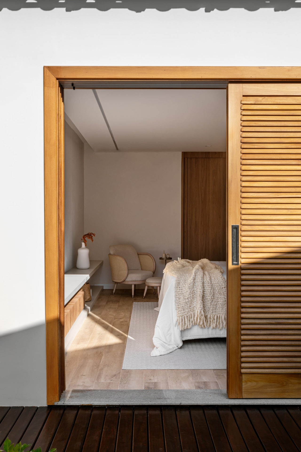 na foto vista parcial do quarto do casal e porta de madeira meio aberta