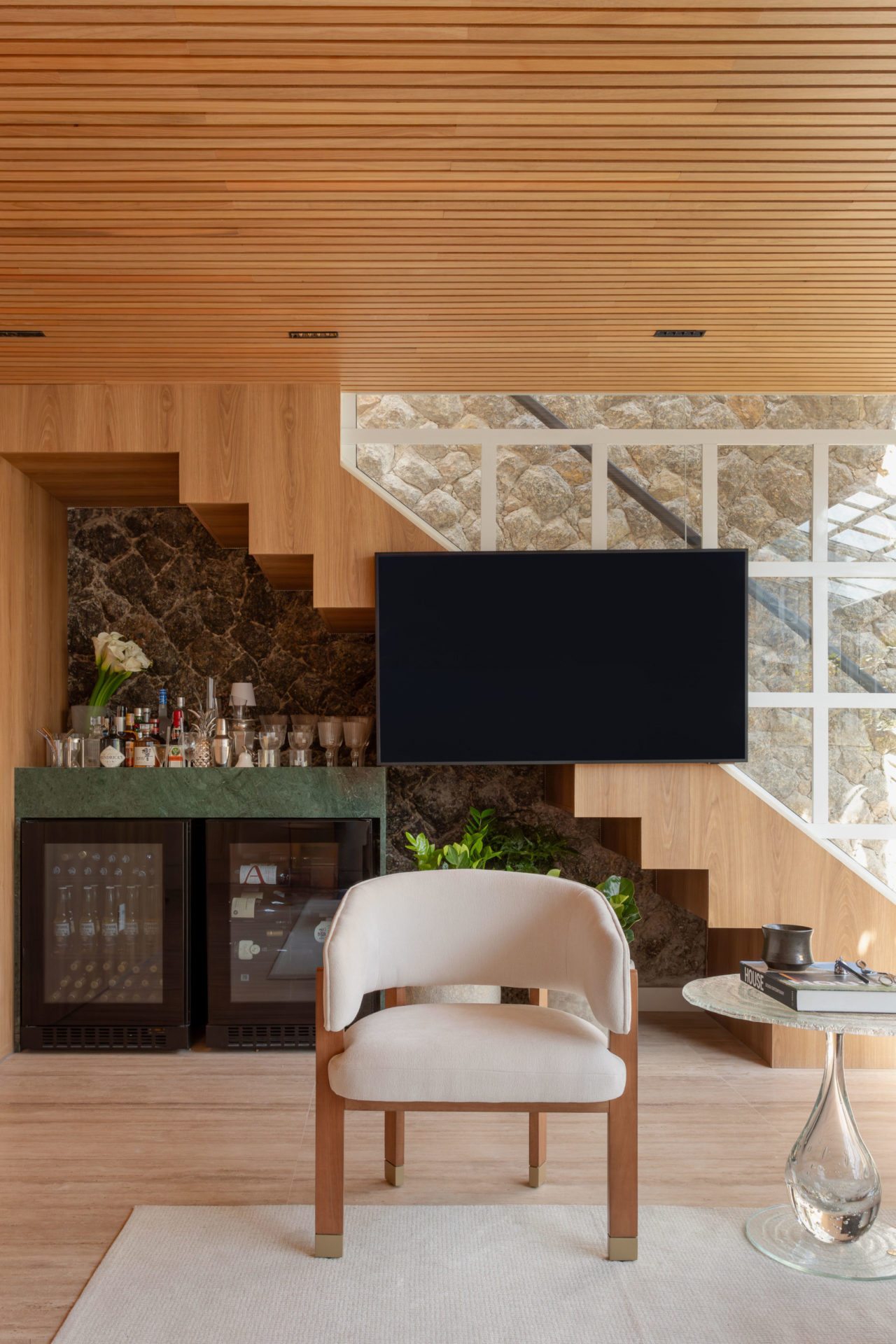 na foto sala com escada, poltrona e uma mesa lateral Emoções, de Luisa Moyses