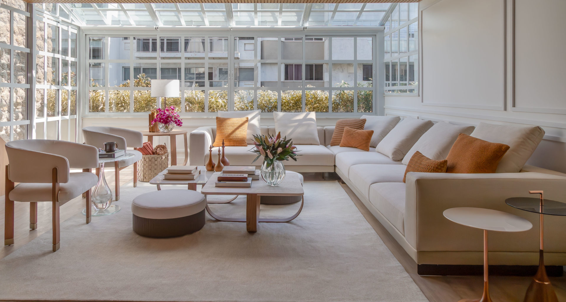 na foto sala ampla com mesa de centro, sofá, janelão e muita luminosidade