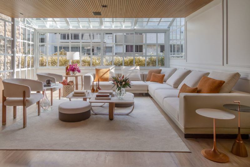 na foto sala ampla com mesa de centro, sofá, janelão e muita luminosidade