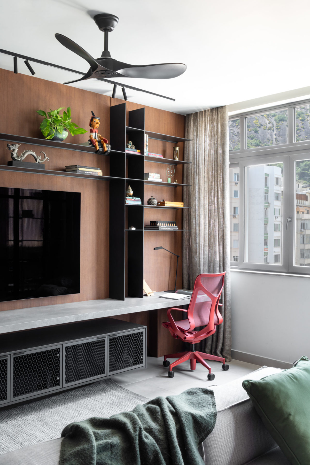 na foto estante com tv e mesa para home office, janela e ventilador de teto