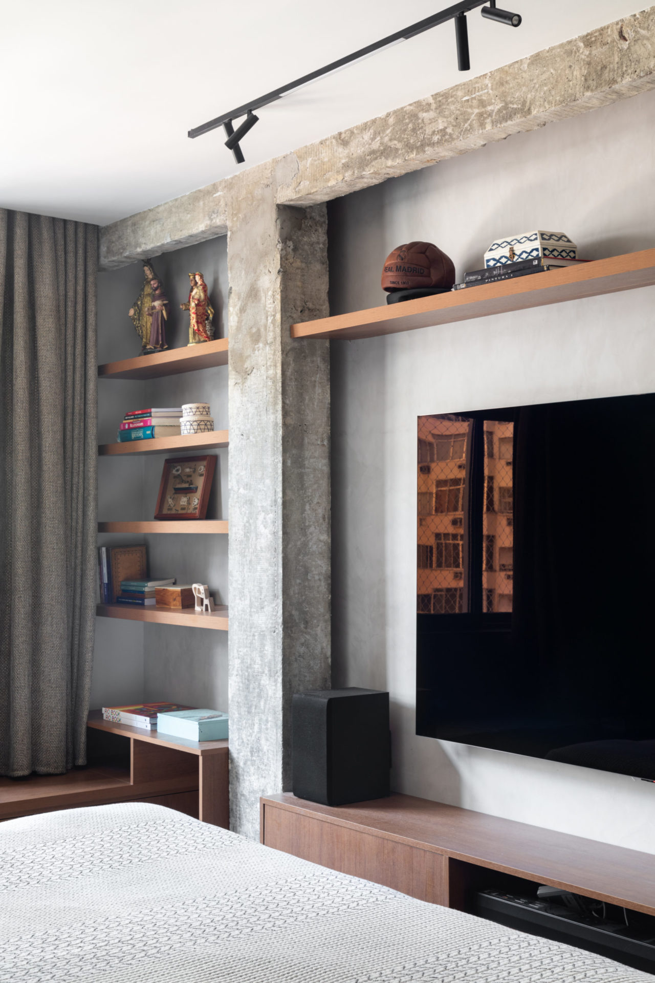 na foto quarto com tv na parede, estante e cama