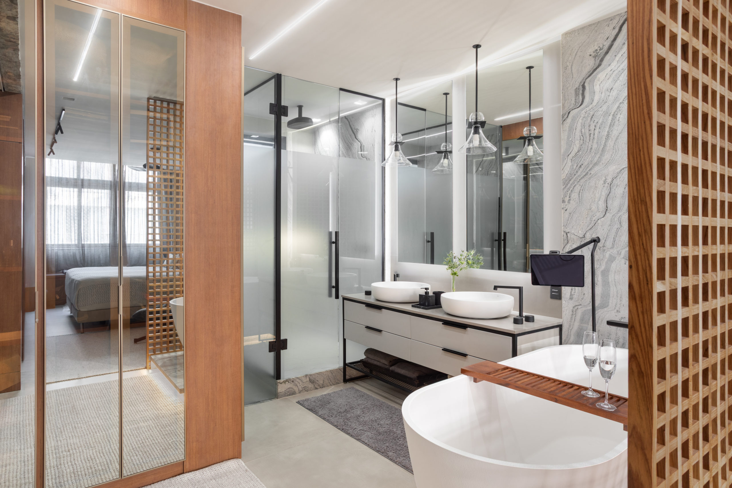 na foto suíte com banheira branca, bancada com duas pias e box