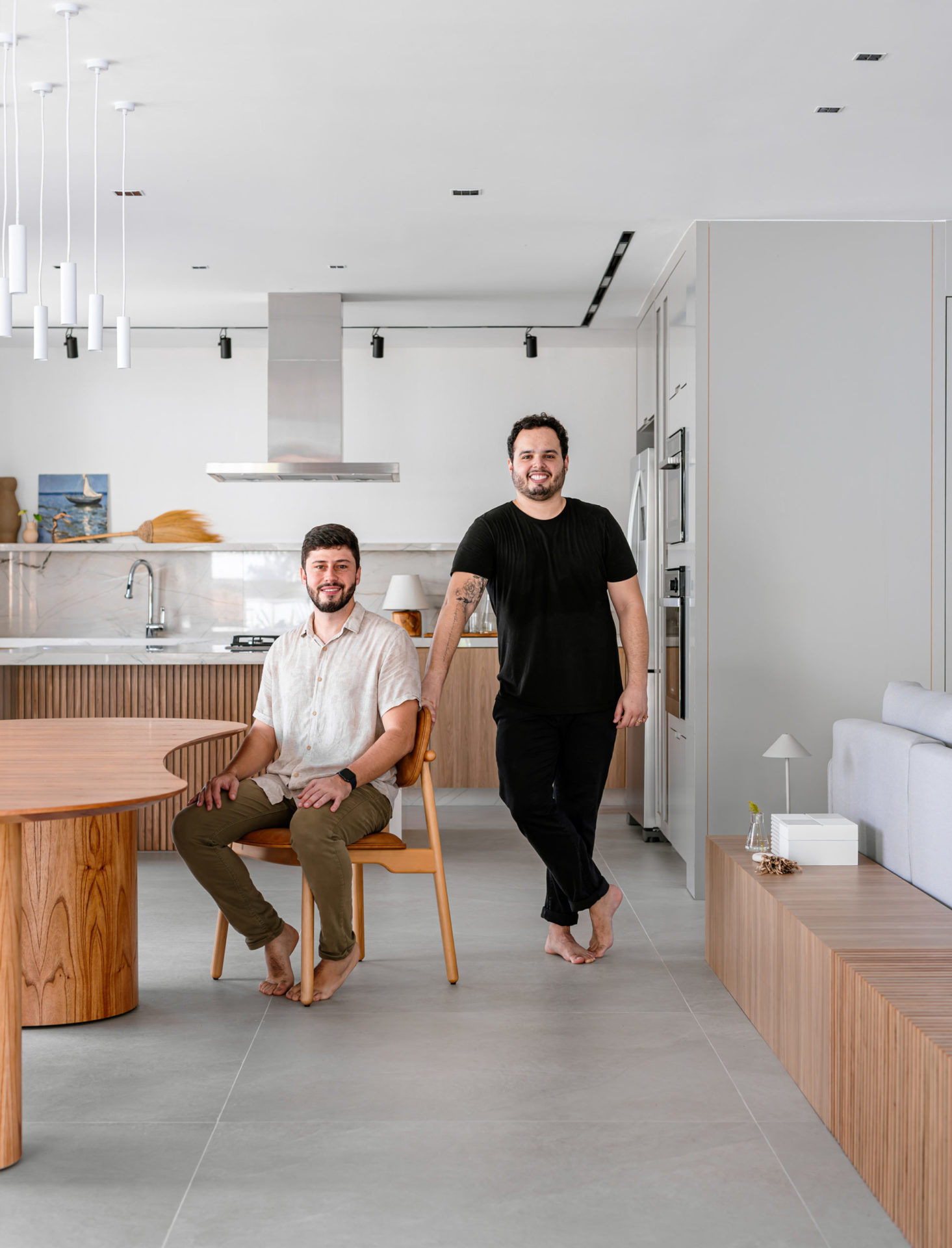 na foto dois homens brancos, um sentado e outro de pé