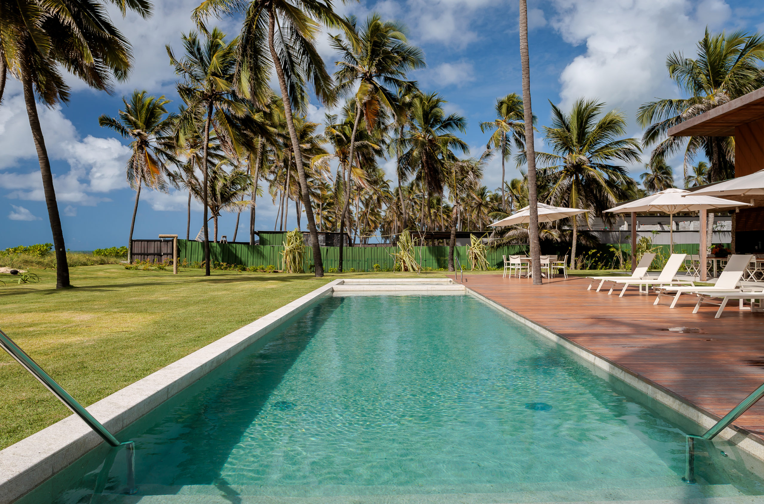 na foto casa de praia com piscina e ampla área verde