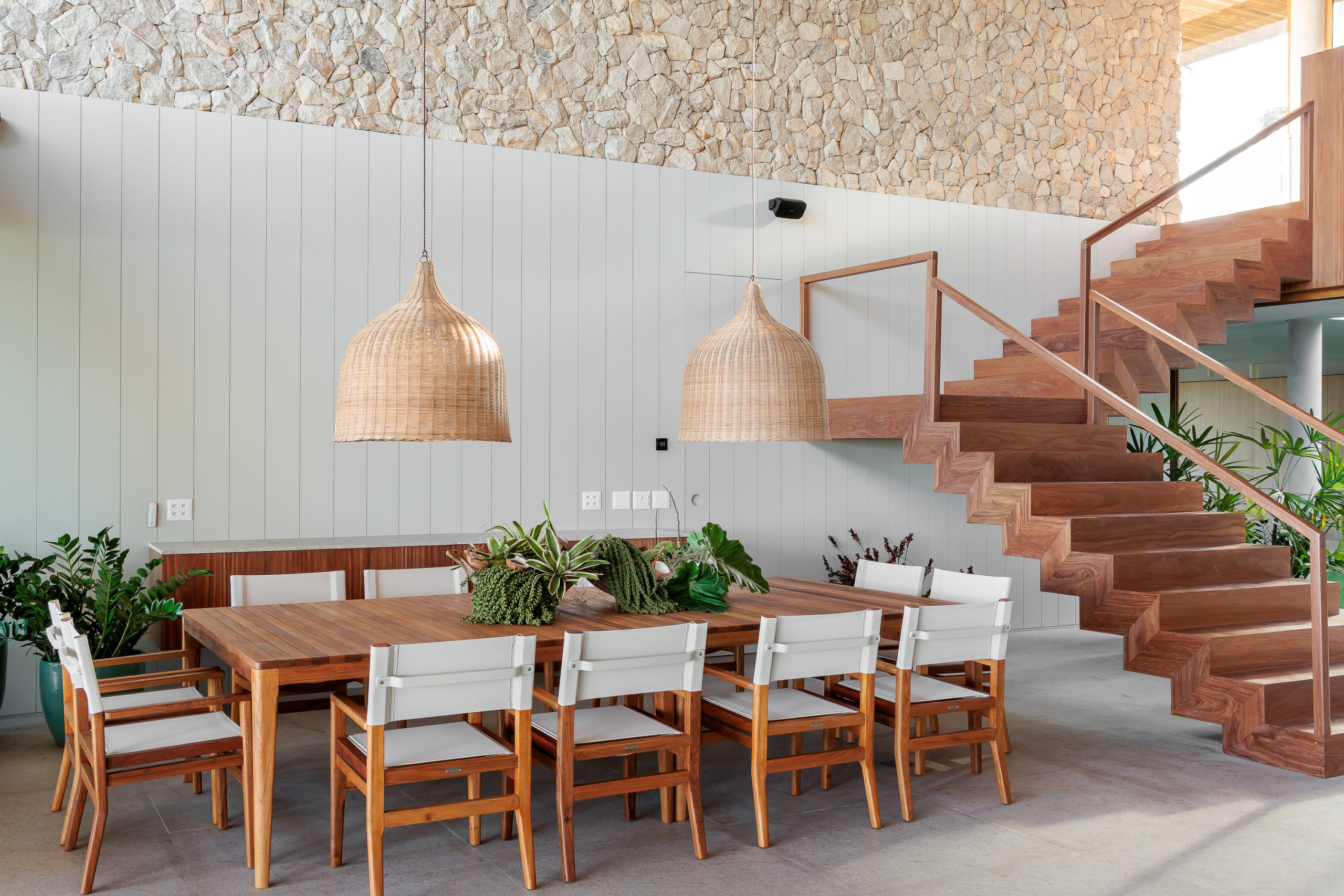 na foto sala de jantar com parede com pedras