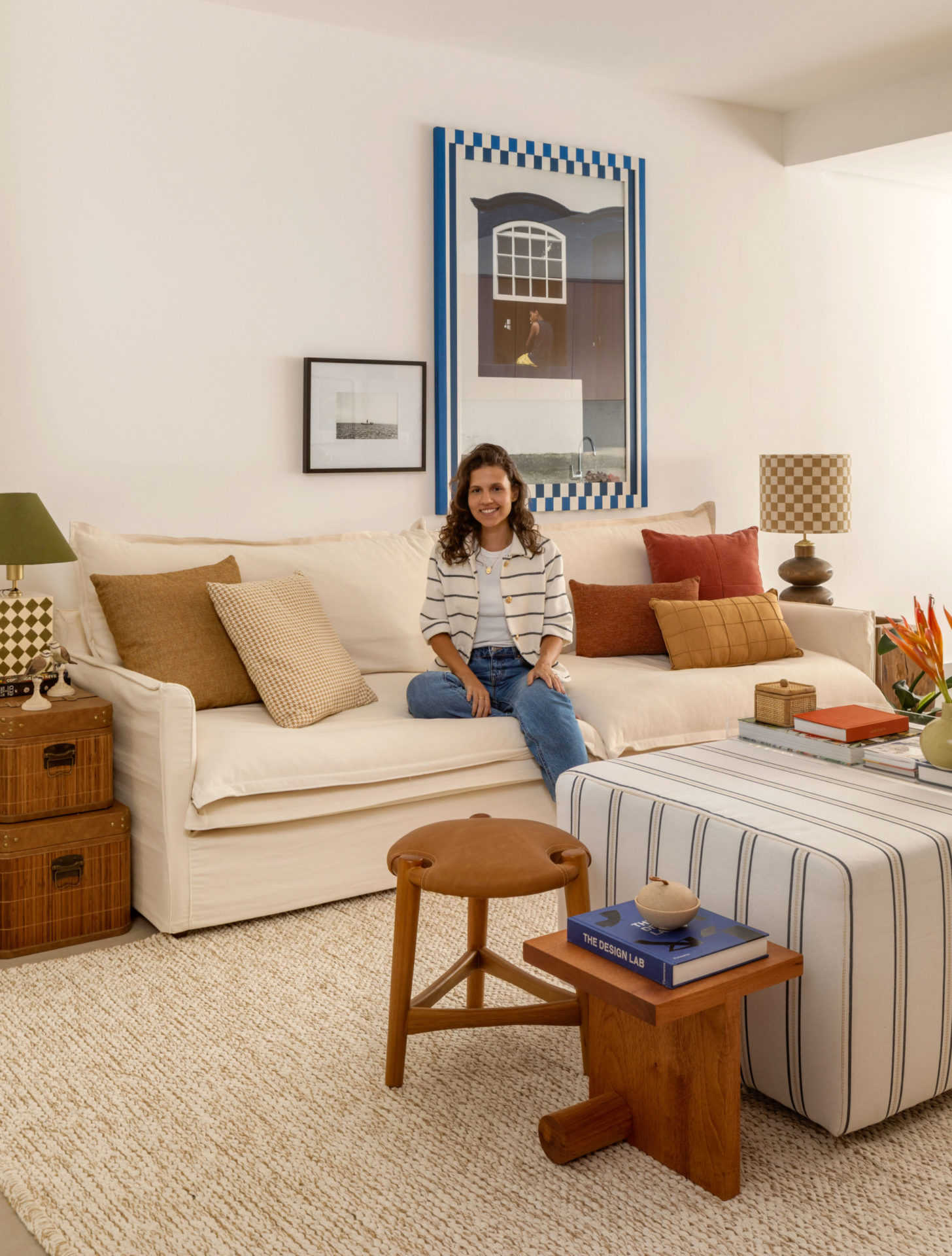 na foto uma mulher branca sentada no sofá da sala de estar