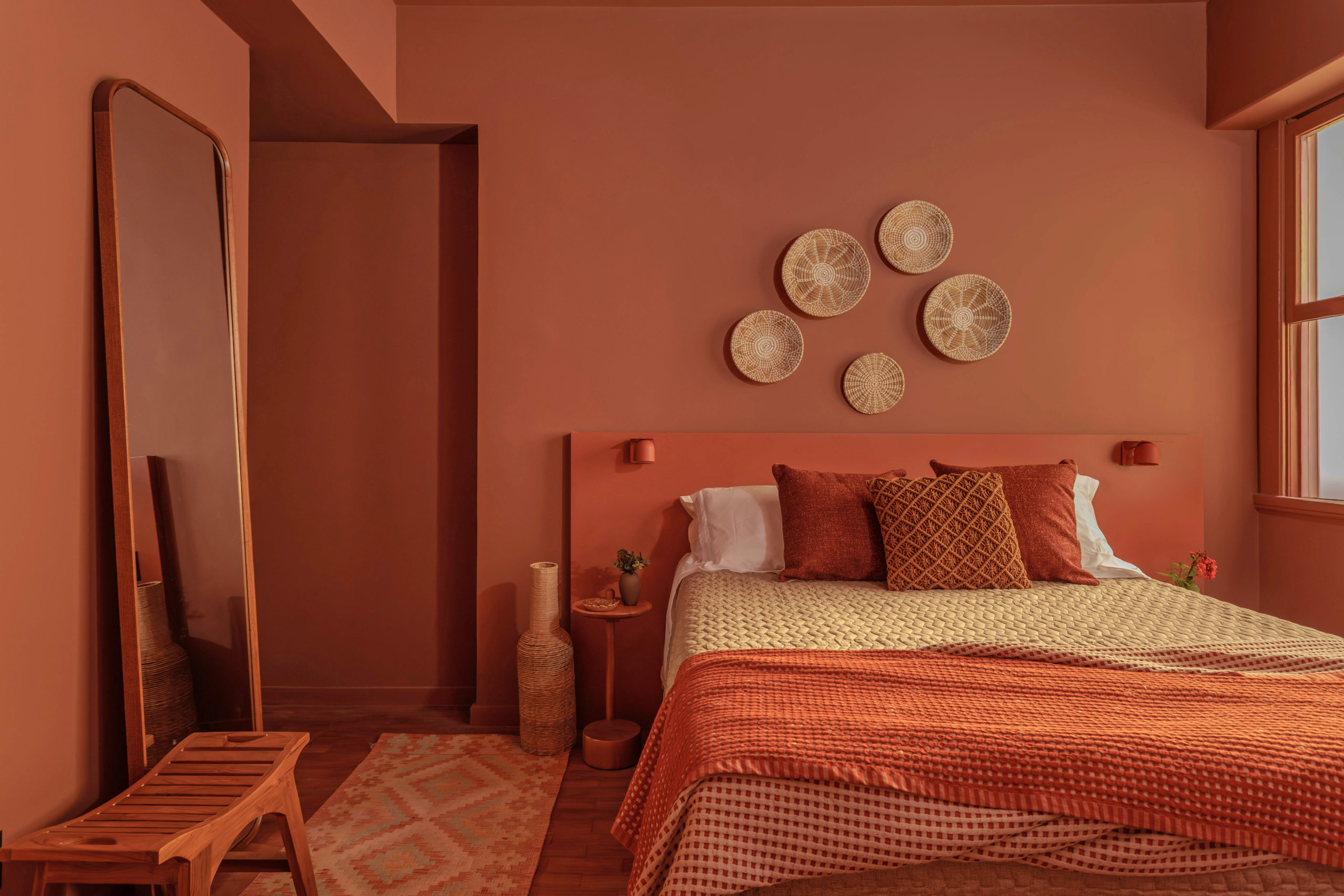 na foto quarto com cama de casal pintado na cor terracota suave