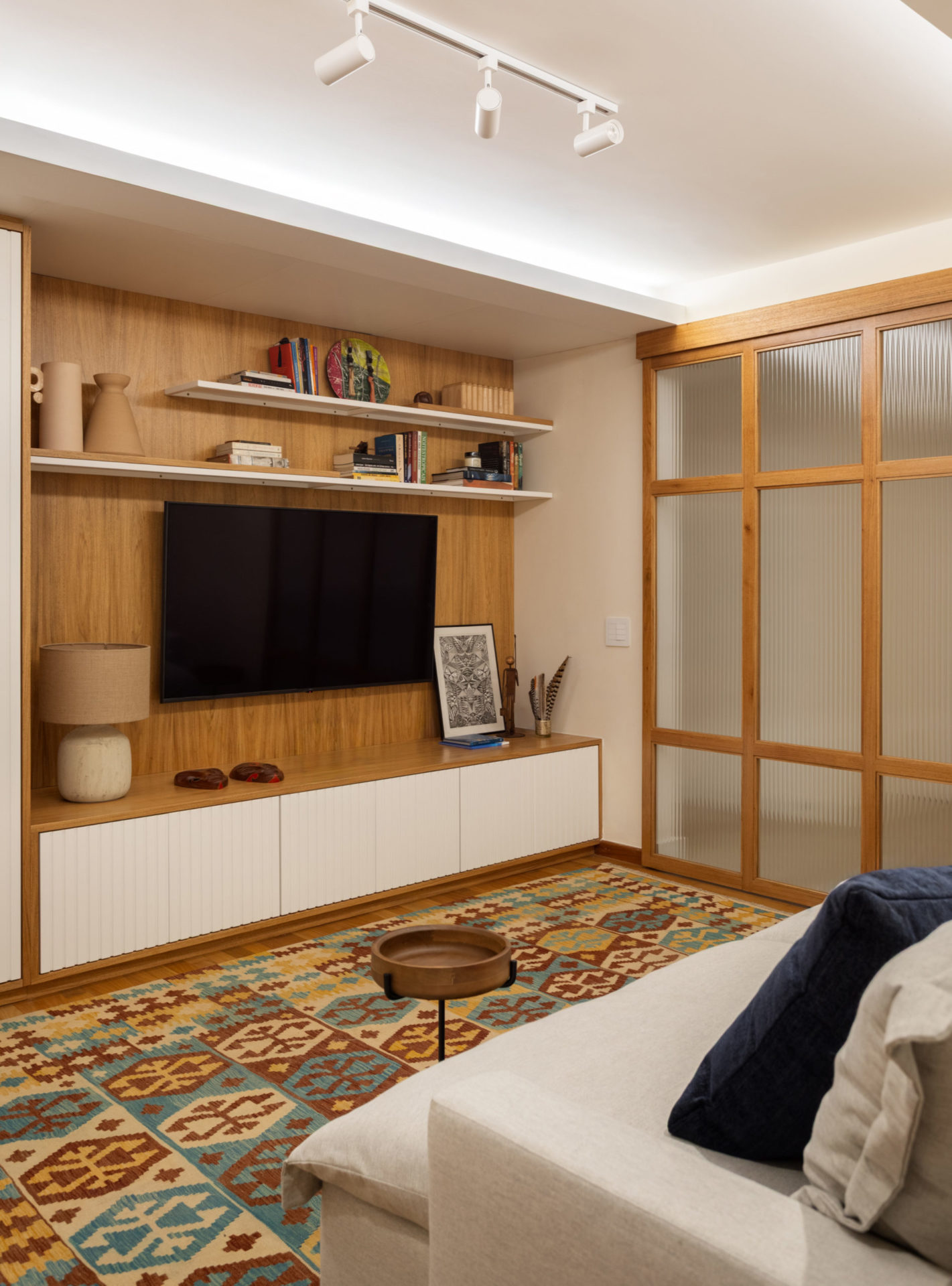 na foto sala de tv com porta em madeira