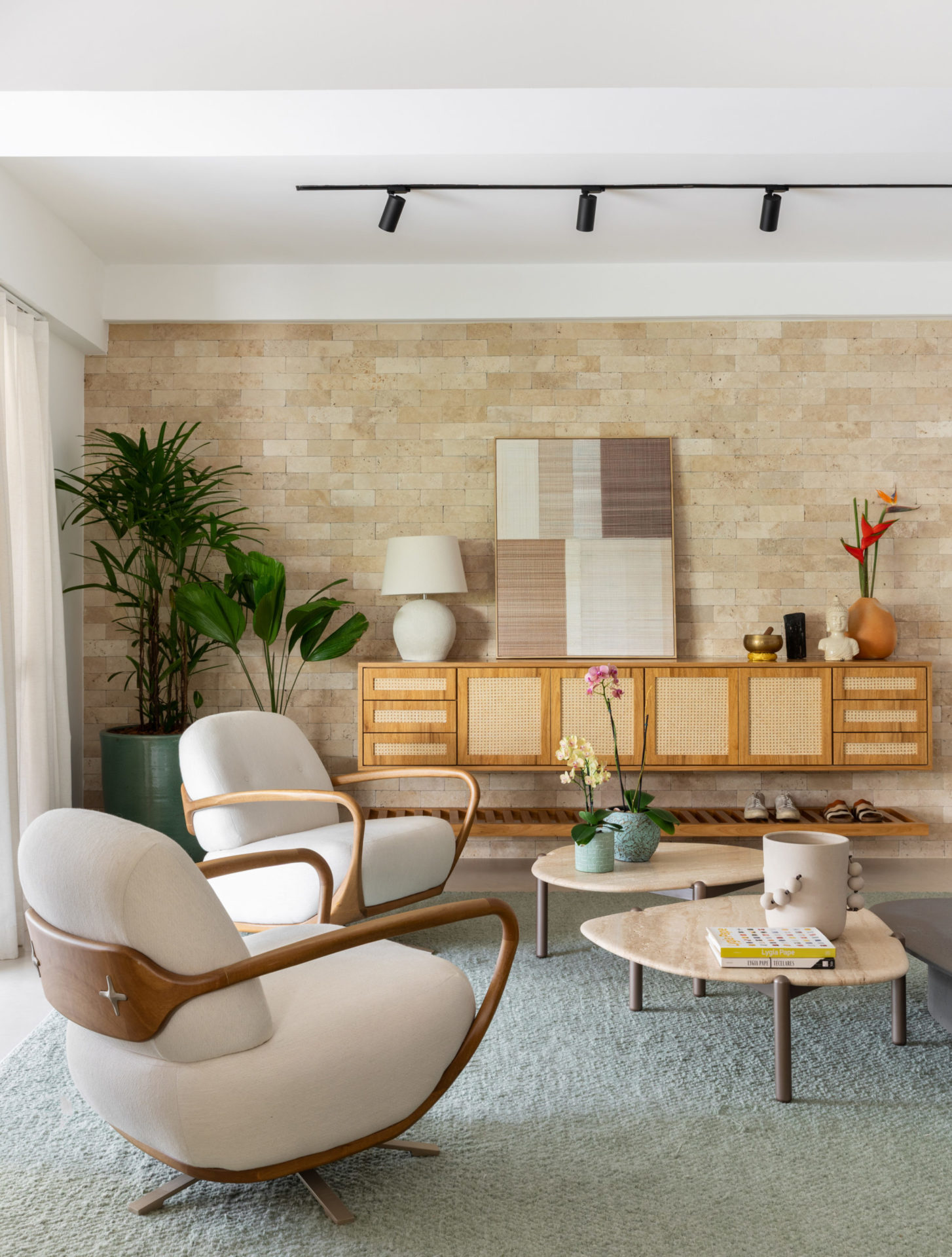 na foto sala com rack em madeira, cadeiras brancas giratórias e mesa de centro