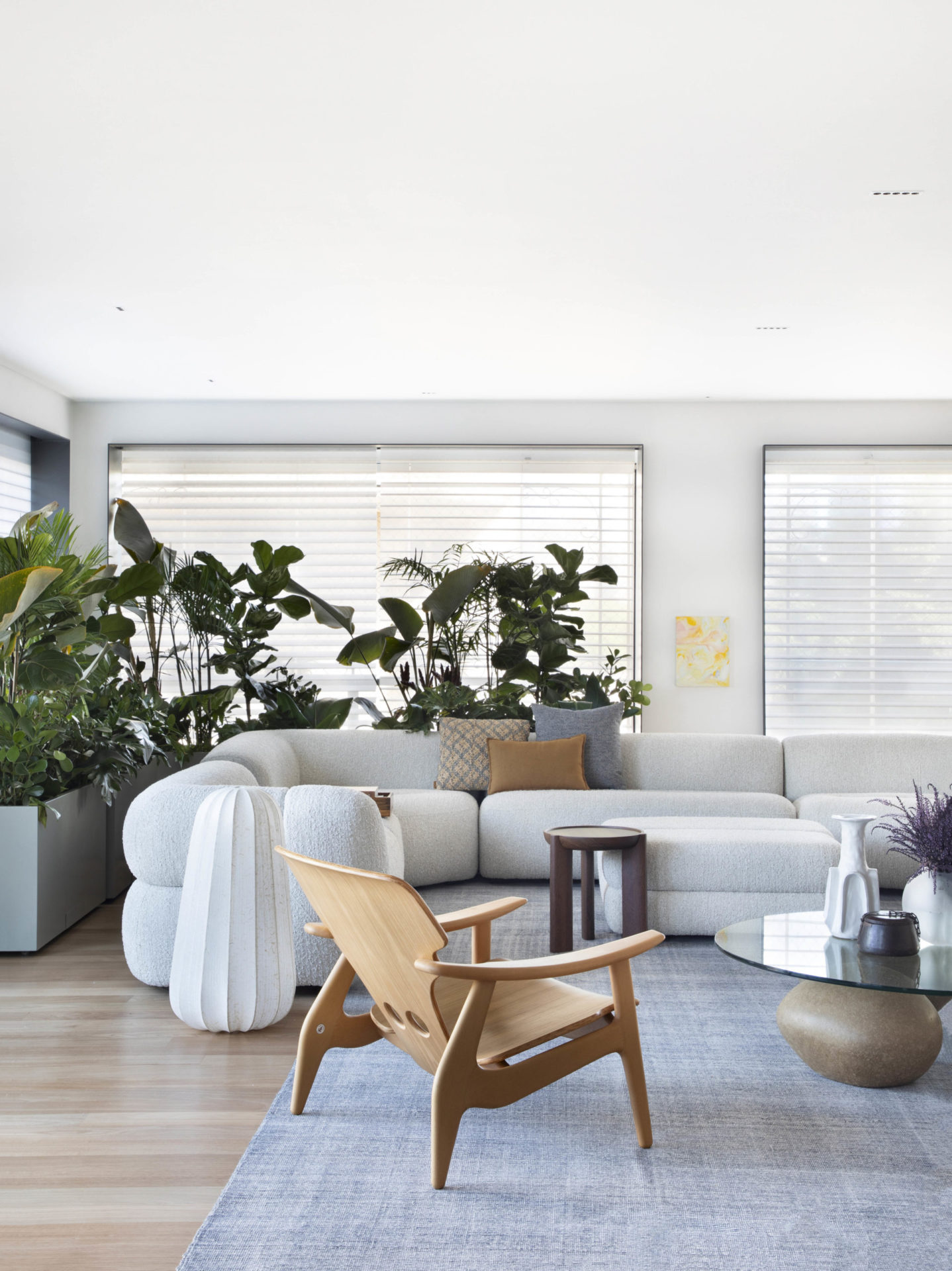 na foto sala com sofá branco e plantas 