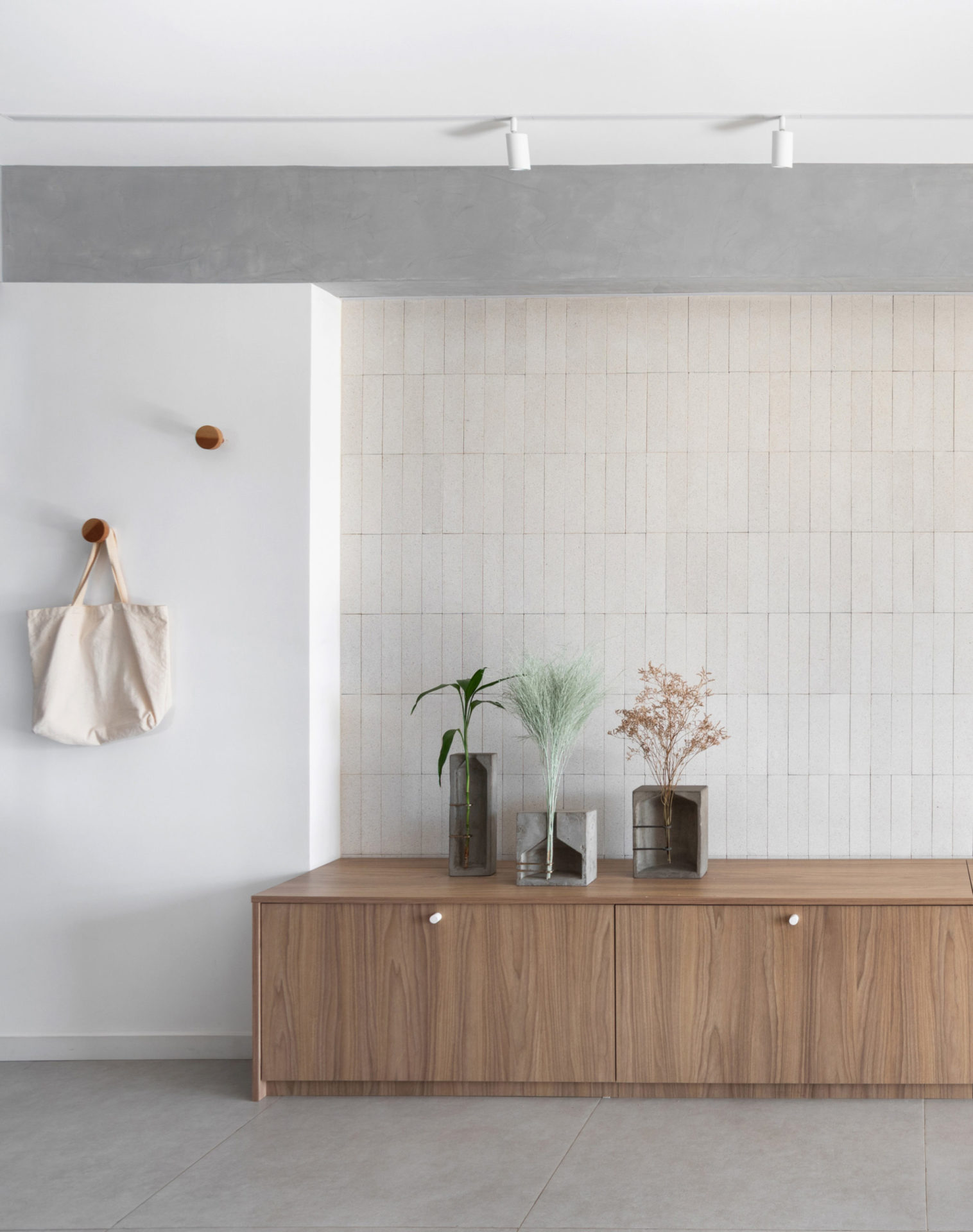 na foto cômodo de apartamento com piso de cerâmica cinza e rack de madeira