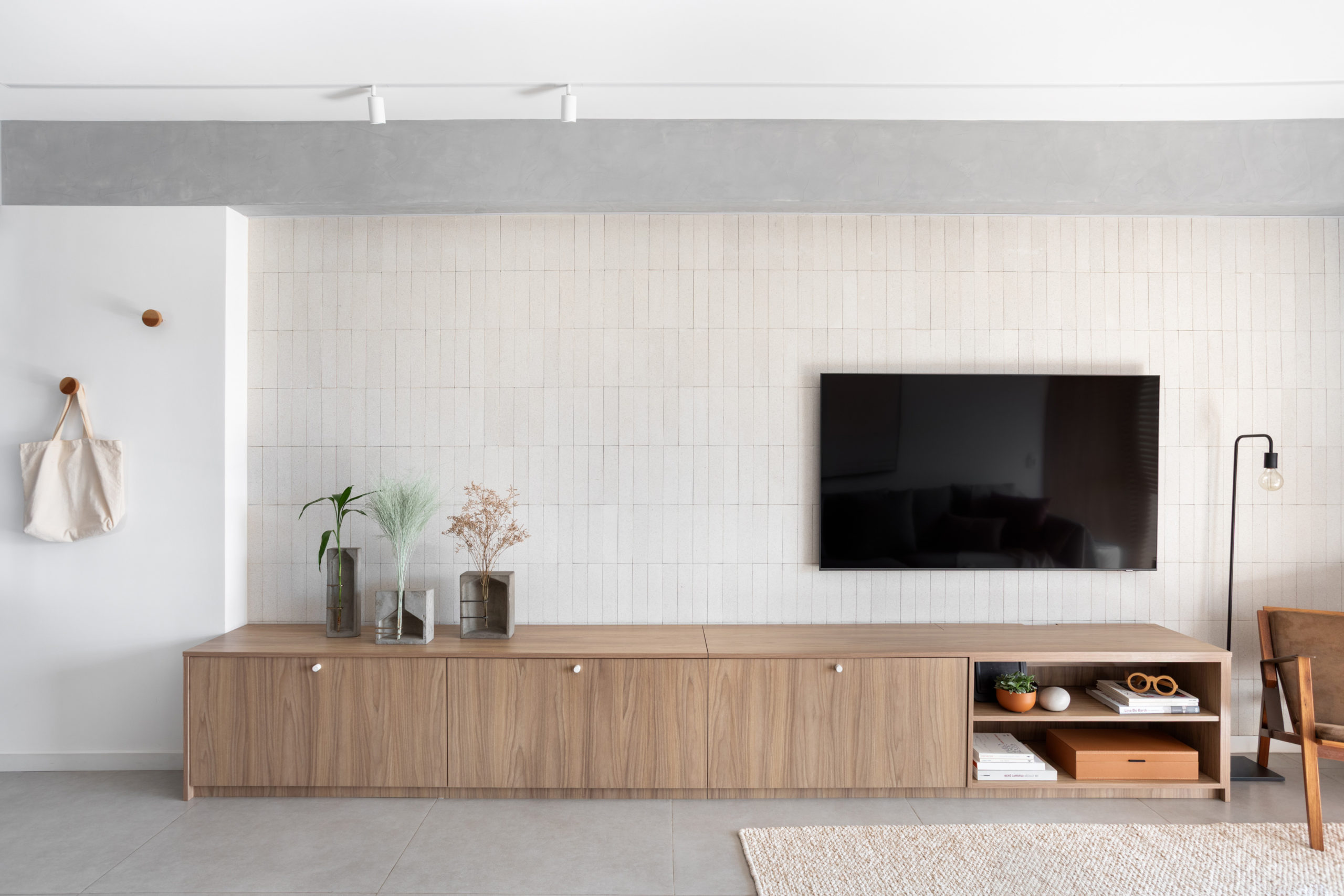 n foto rack de madeira com TV e vasos de concreto com flores