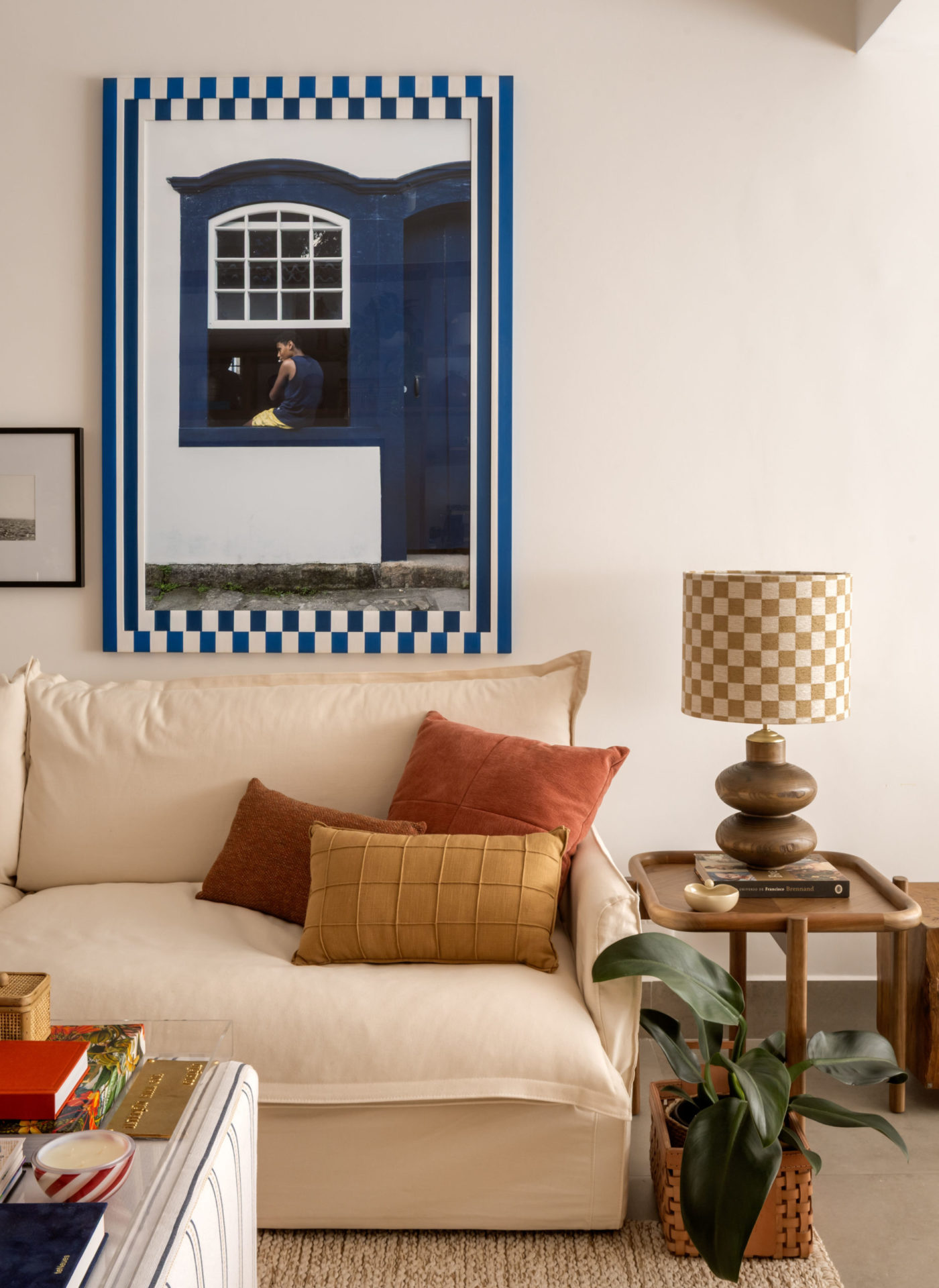 na foto sofá branco, mesa de centro e quadro na parede