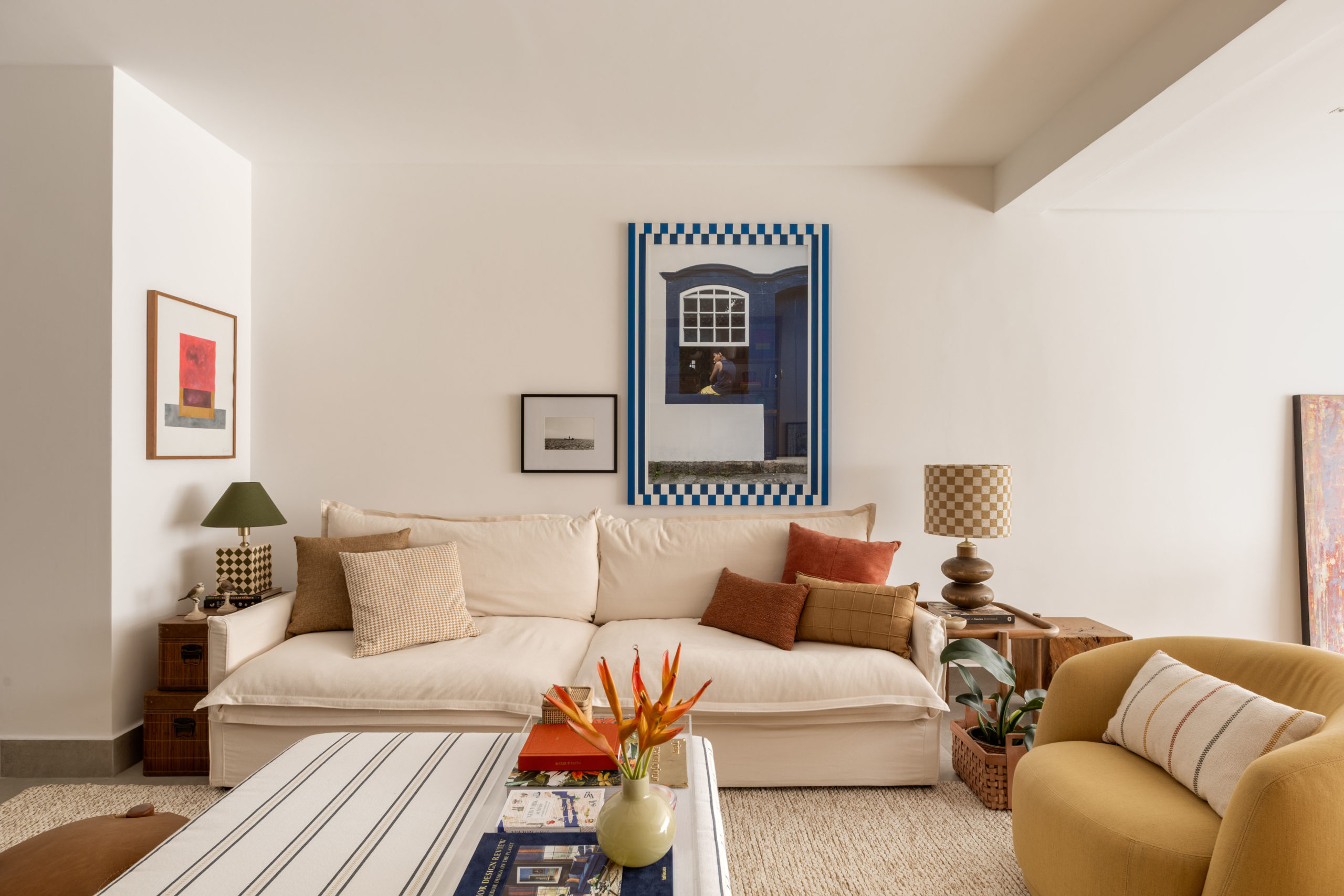 na foto sala com tapete, sofá branco, mesinhas de canto e mesa de centro