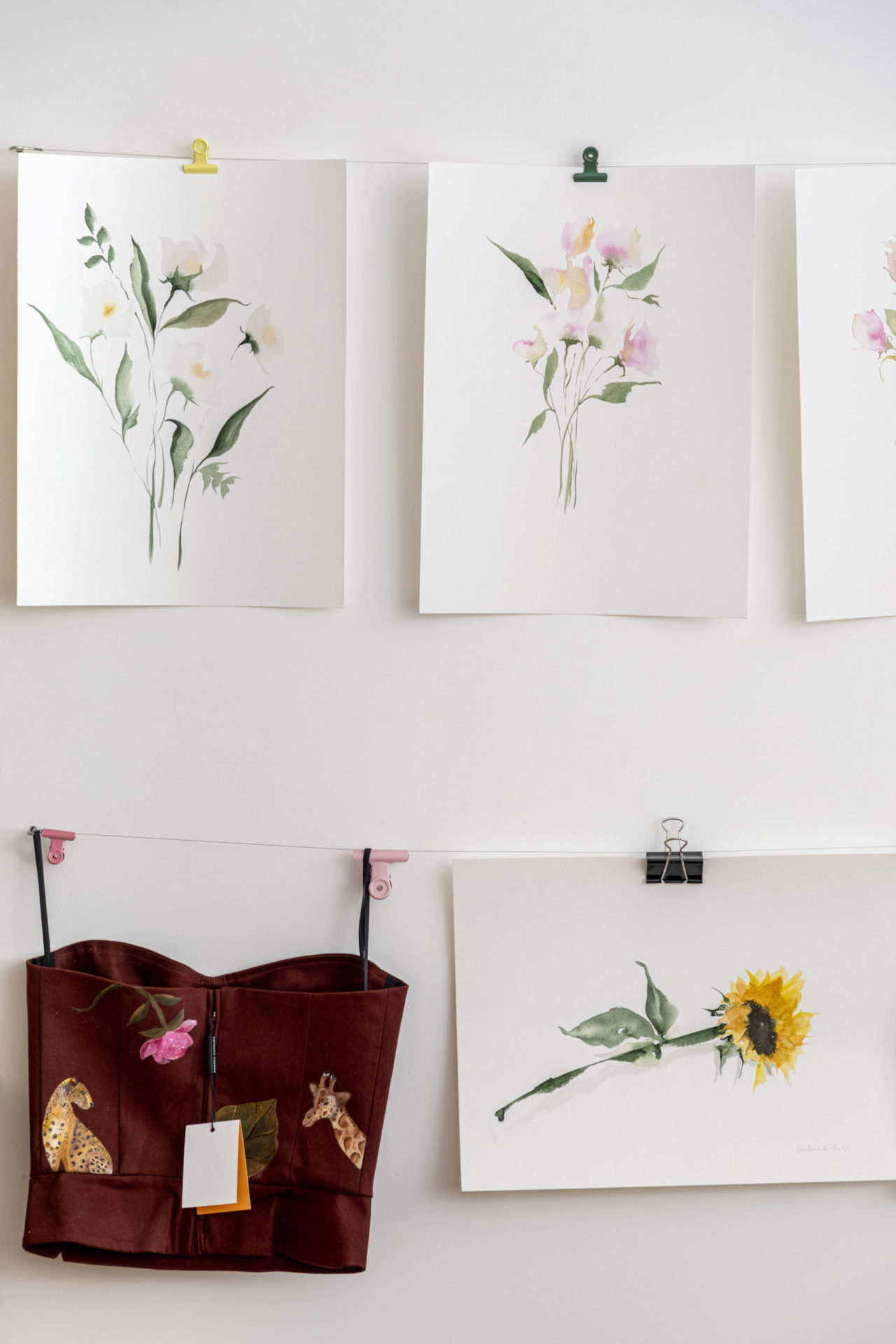 na foto quatro aquarelas presas à parede