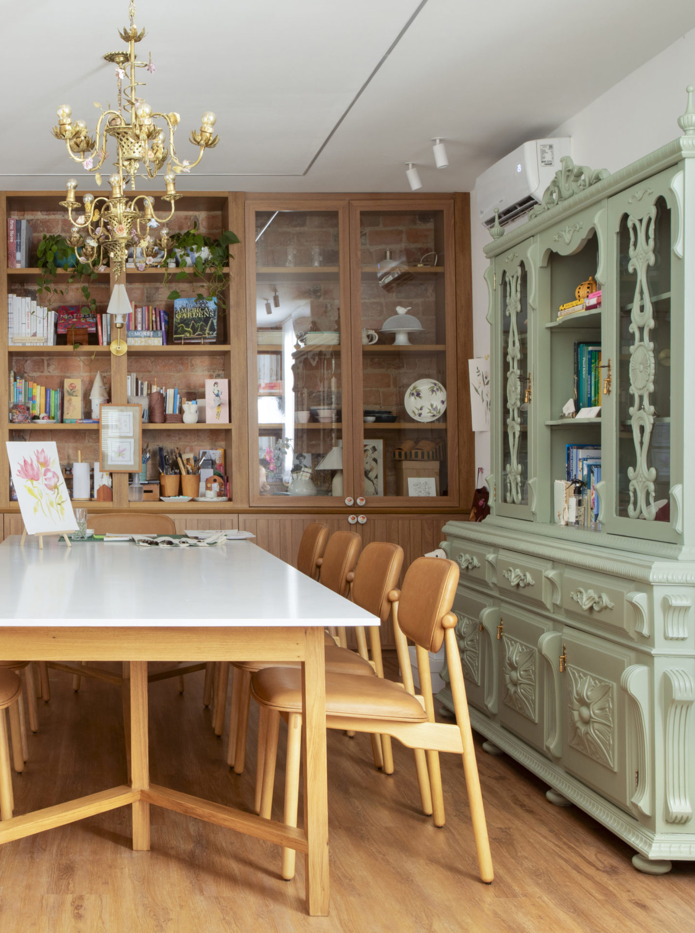 na foto mesa com seis cadeiras, estante de madeira e uma estante de madeira pintada de verde