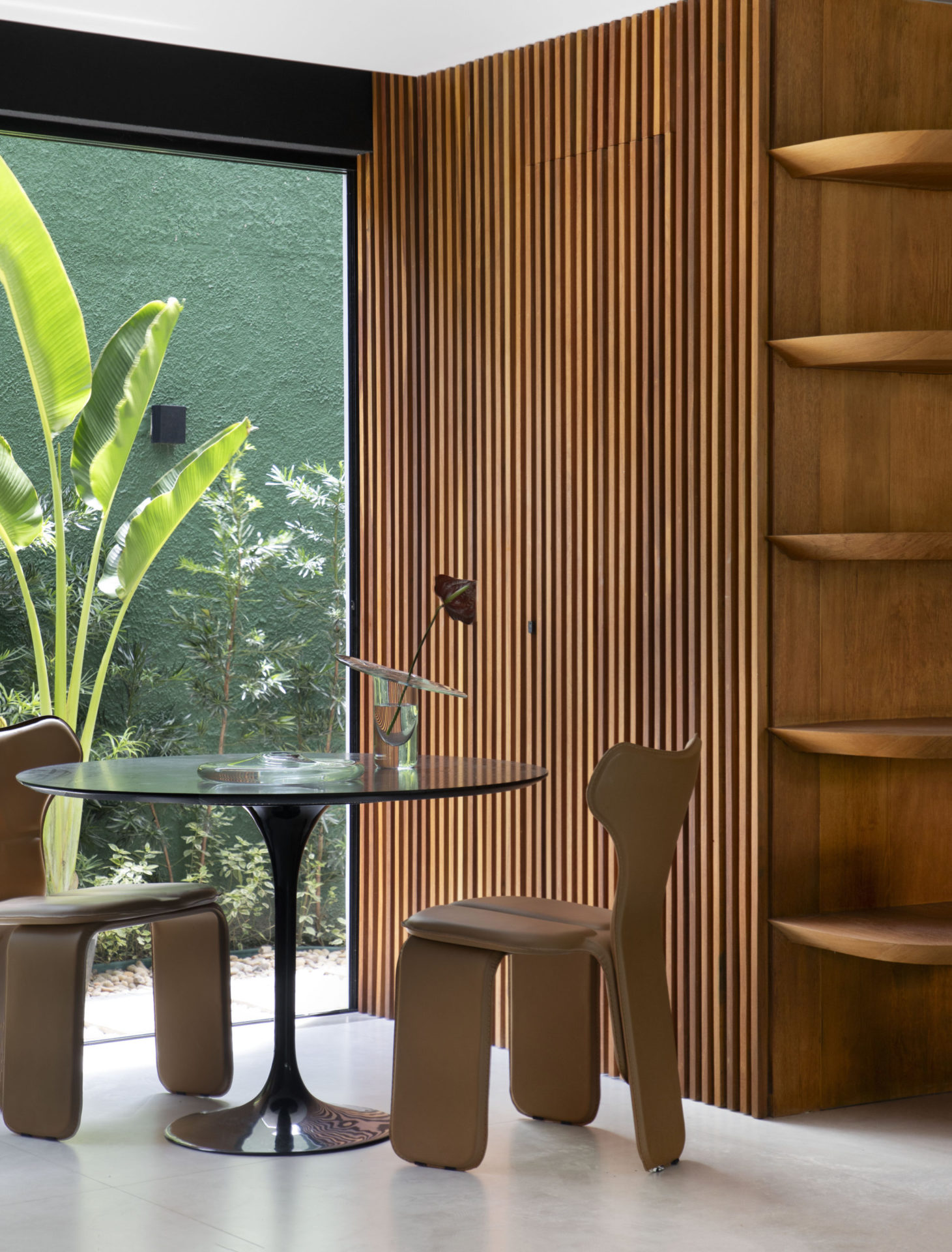 na foto parte interna de casa com varanda com mesa para duas pessoas