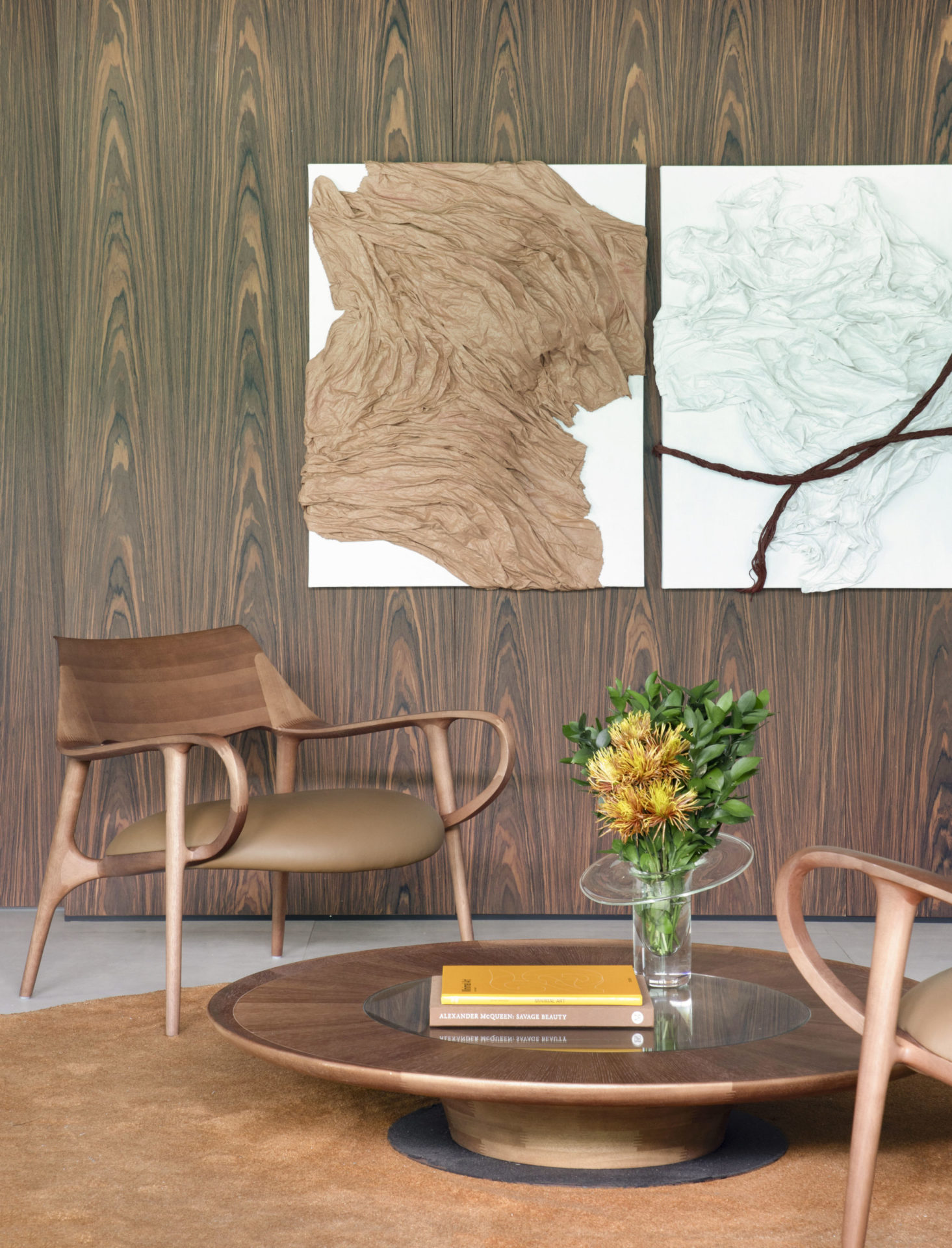 na foto mesa redonda, poltrona e quadro na parede