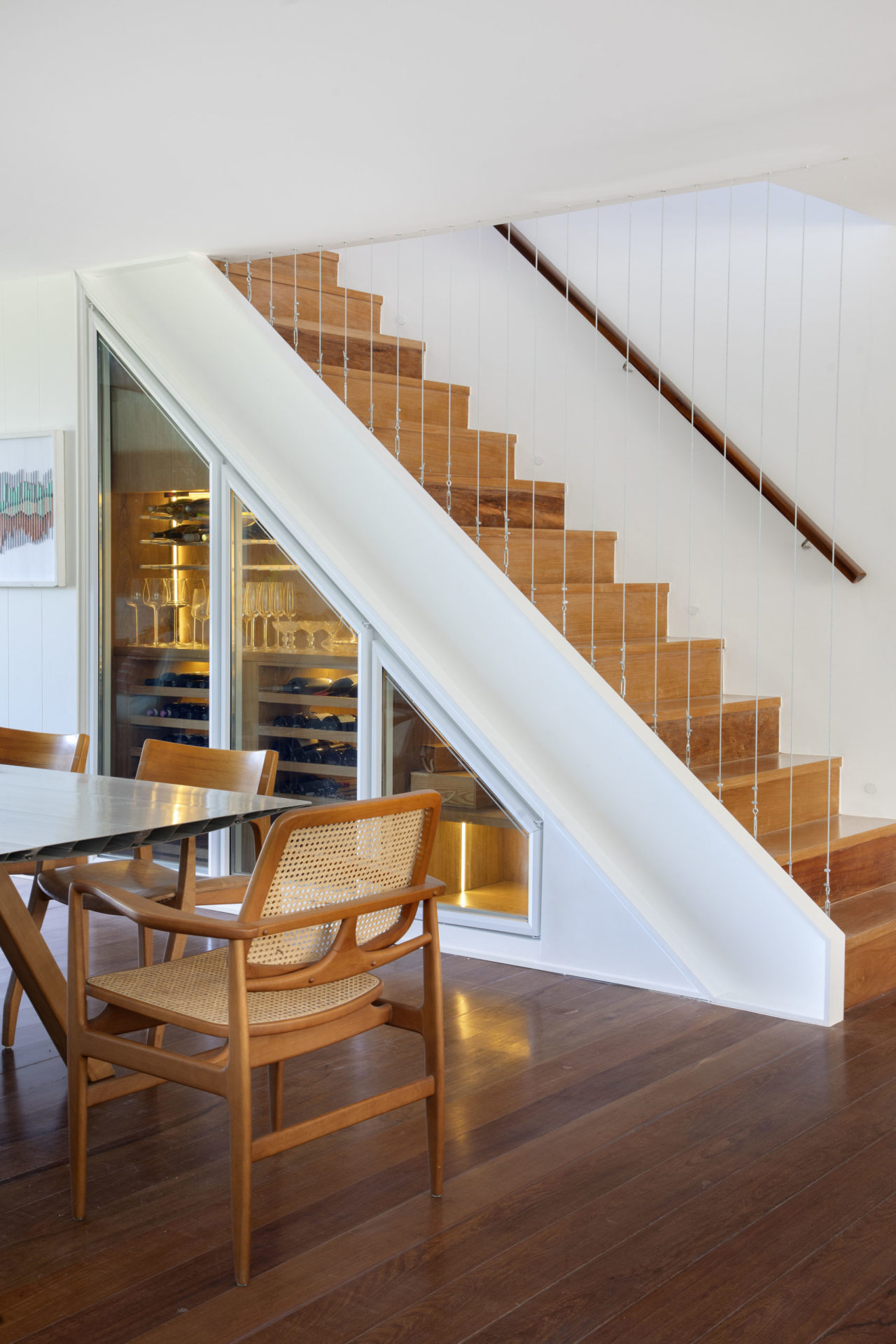 na foto sala com escada com adega abaixo da escada