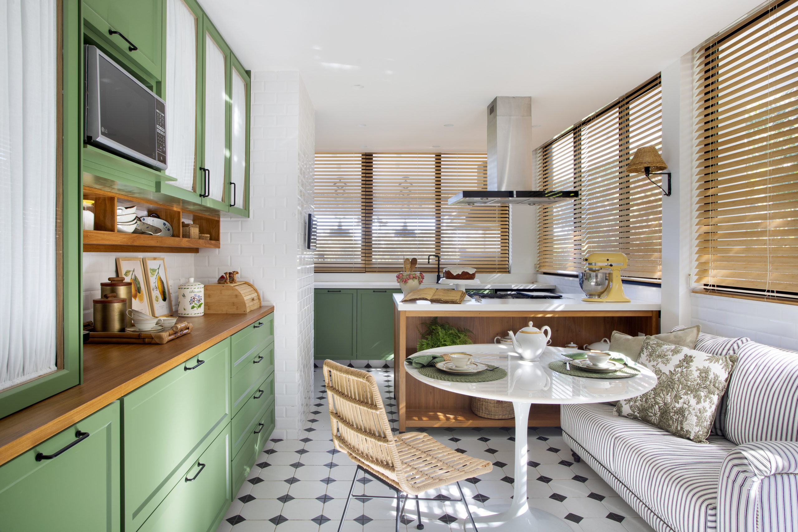 na foto copa cozinha com armários na cor verde e mesa na cor branca