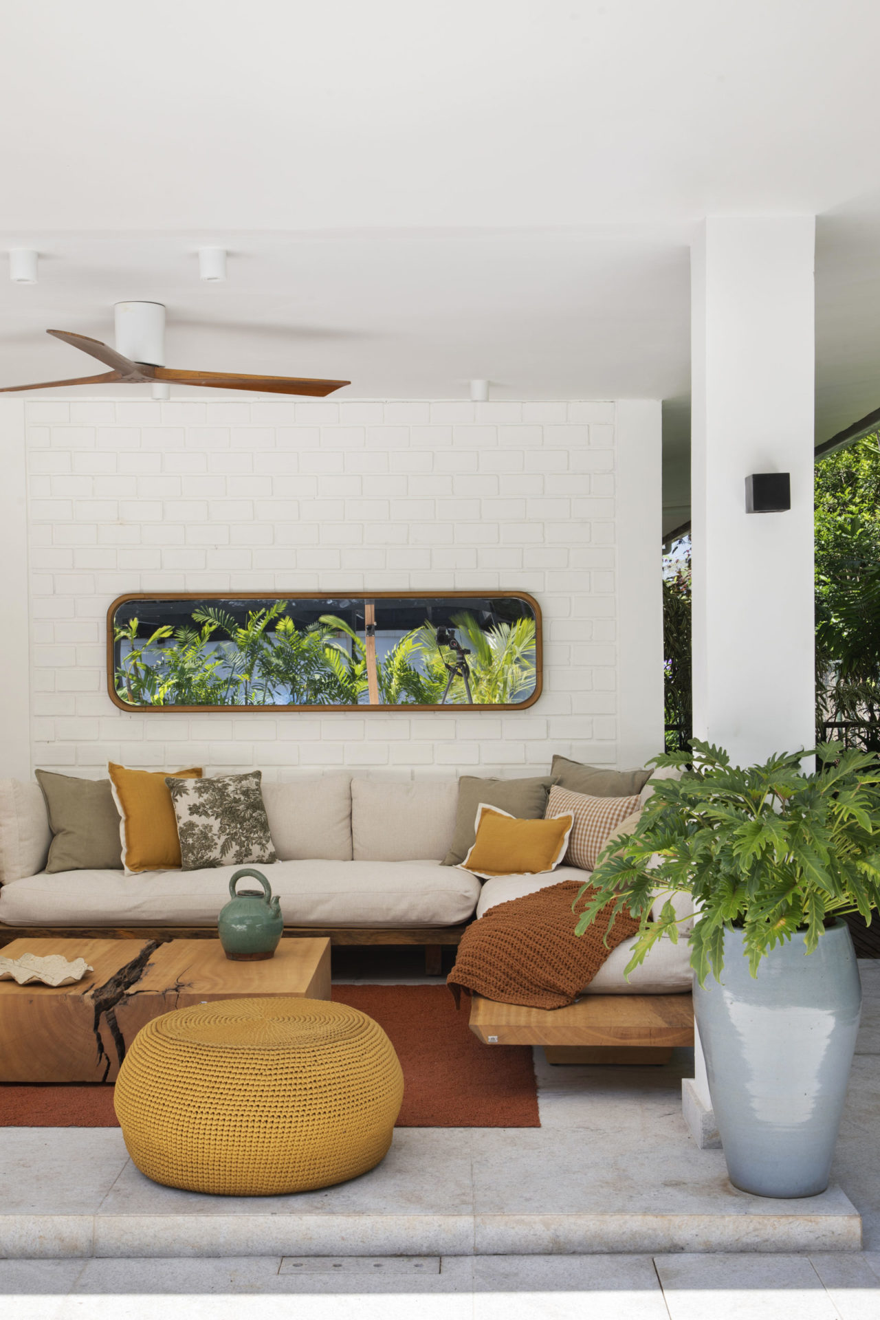 na foto sala com espelho na parede acima do sofá e mesinha de centro