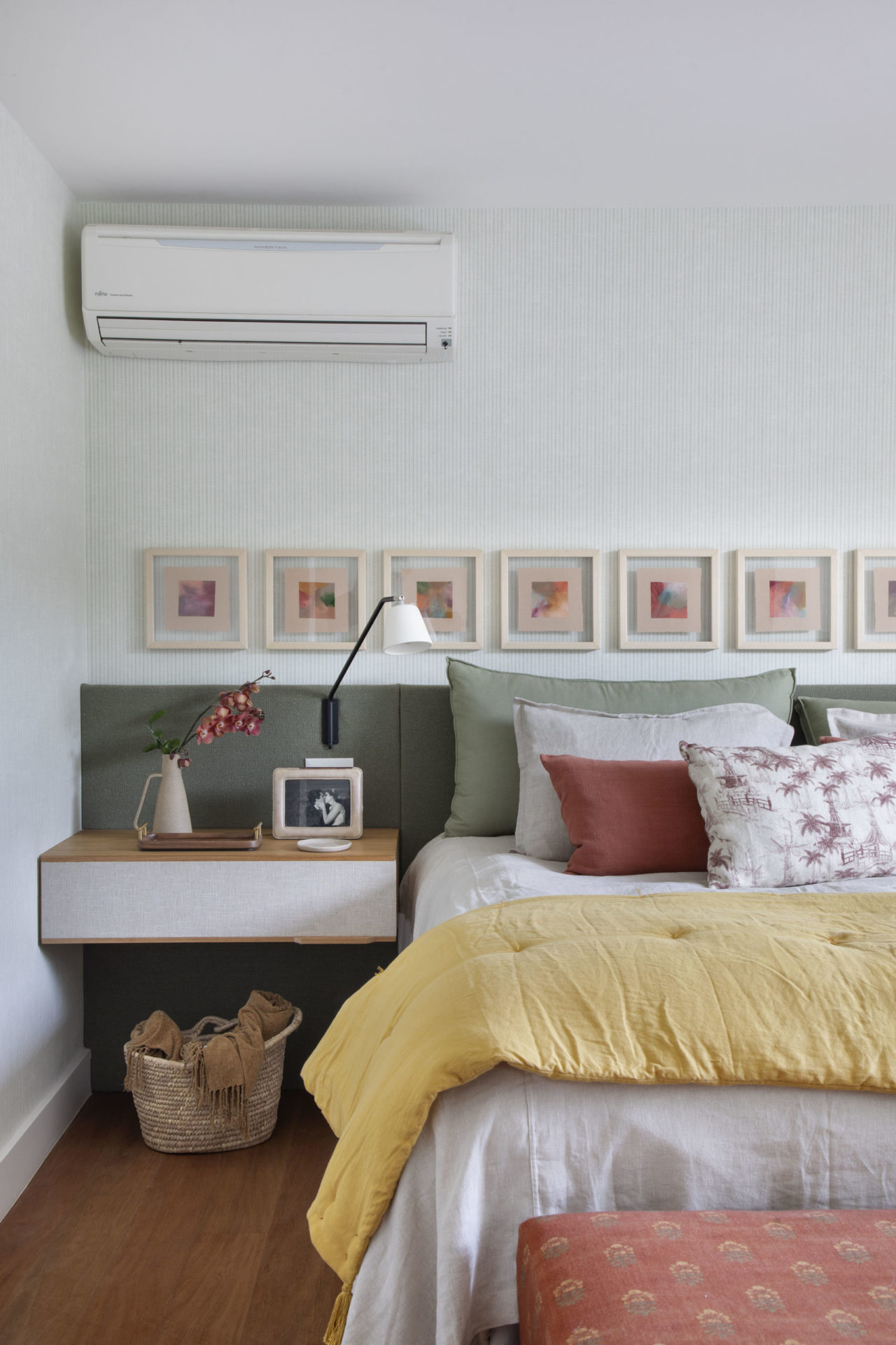 na foto quarto com cama de casal, mesa de cabeceira e quadros na parede