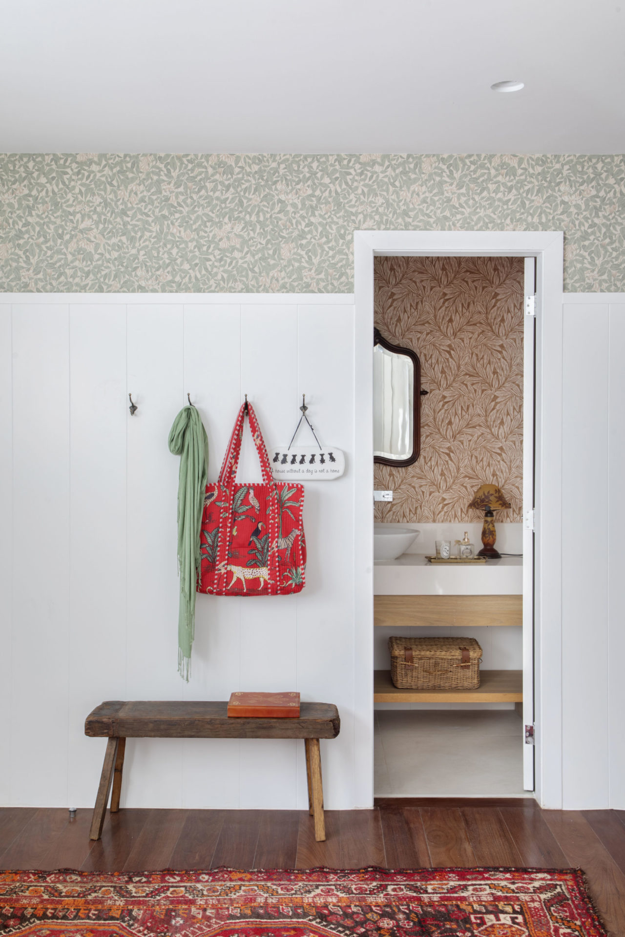 na foto hall com piso de madeira e porta aberta do lavabo