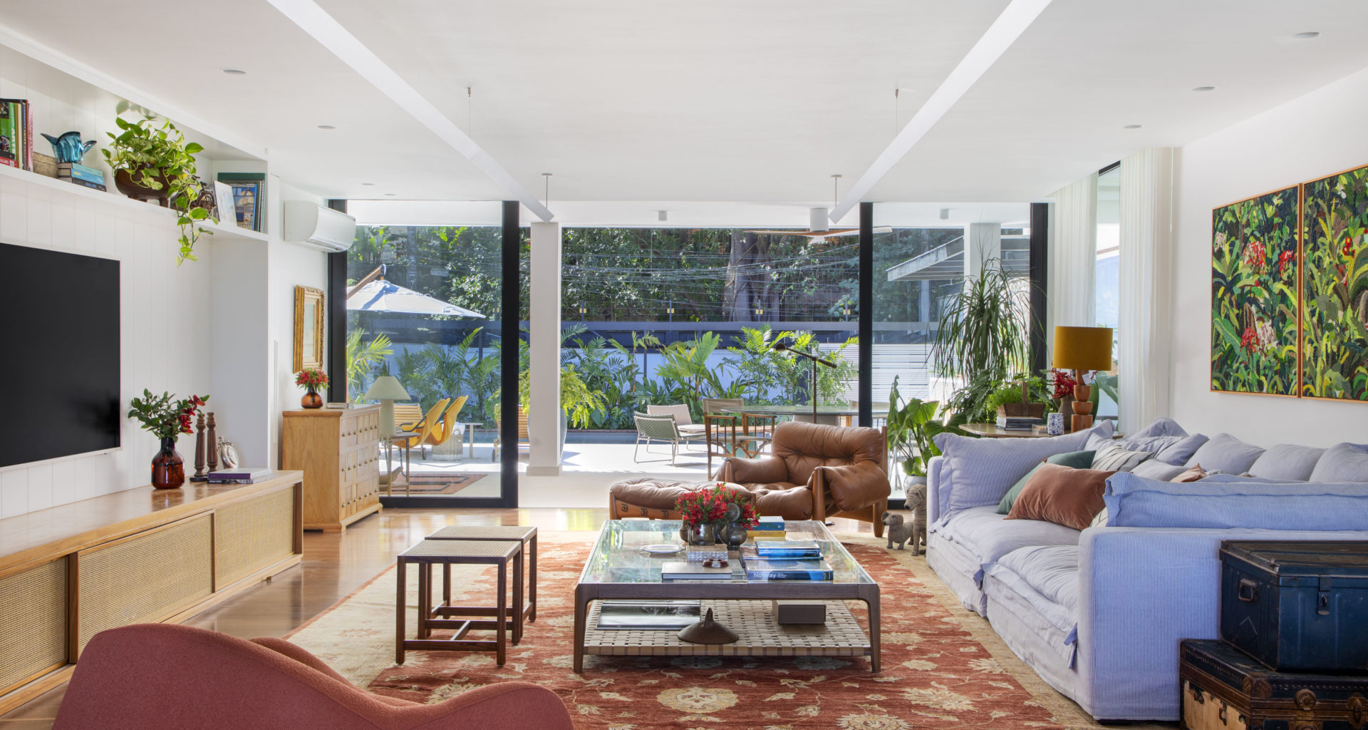 na foto sala com sofá, poltrona de couro e TV