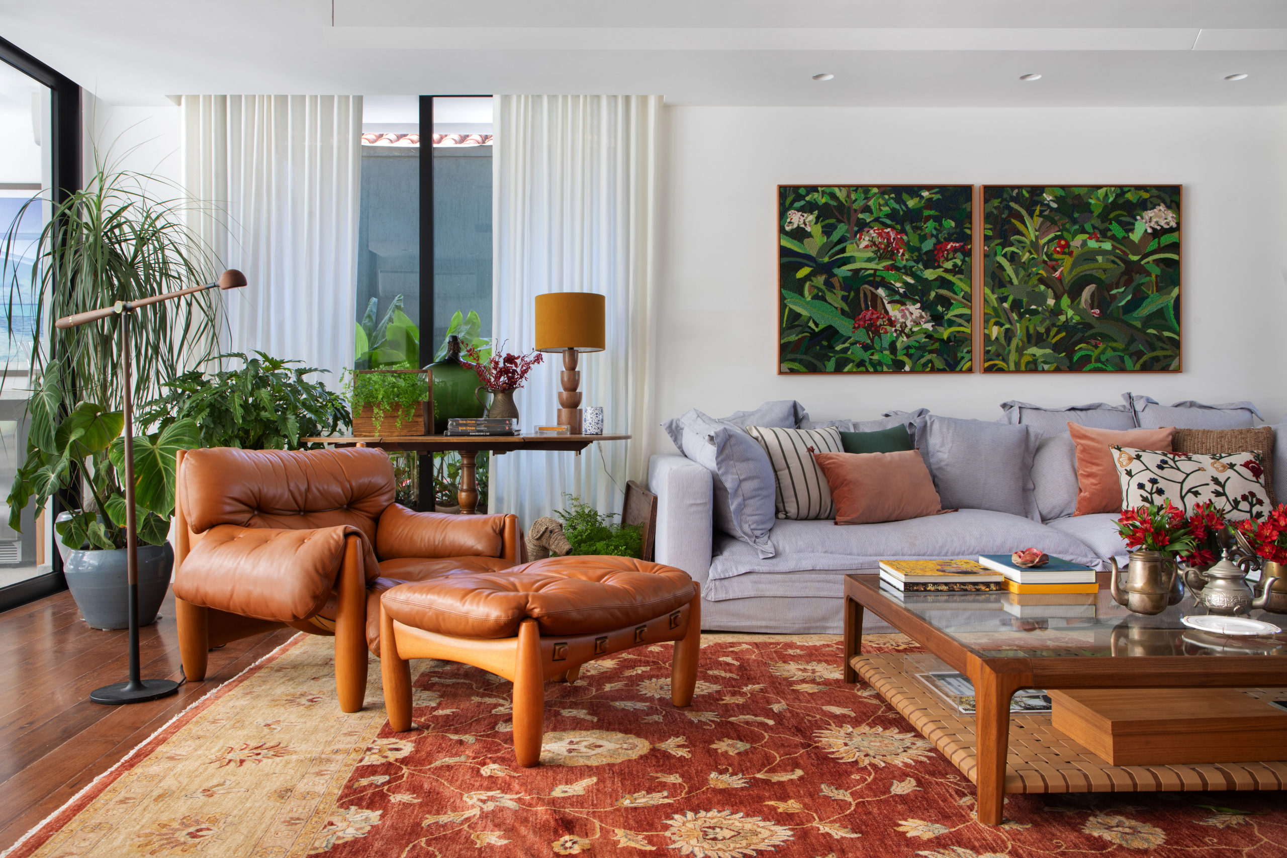 na foto sala com quadro de natureza morta na parede, sofá e poltrona