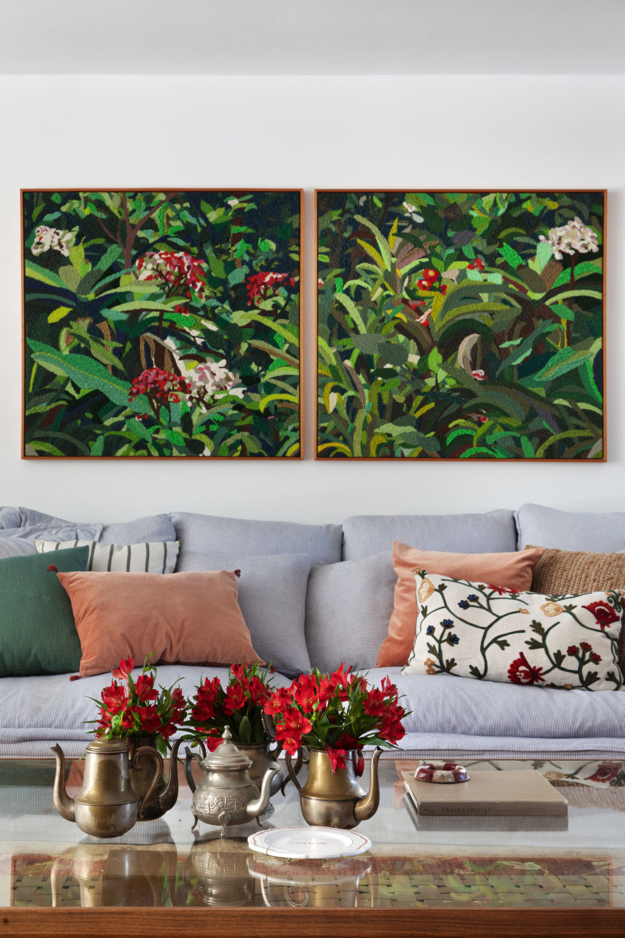 na foto sofá com dois quadros na parede