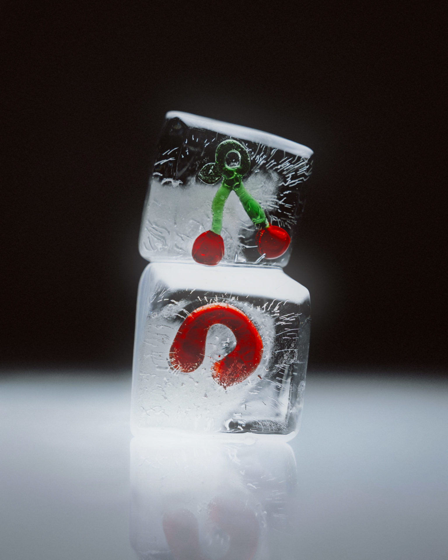 na foto dois cubos de gelos, um em cima do outro, com objetos em vermelho dentro