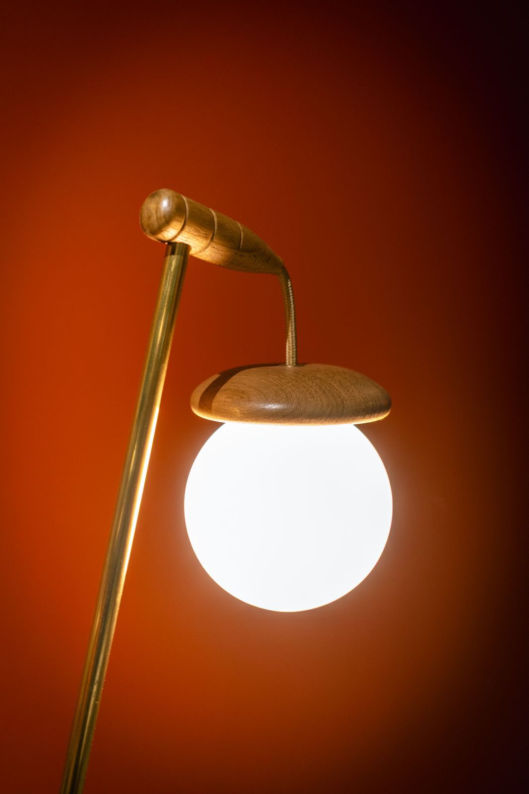 na foto uma parede vermelha e uma lâmpada acesa