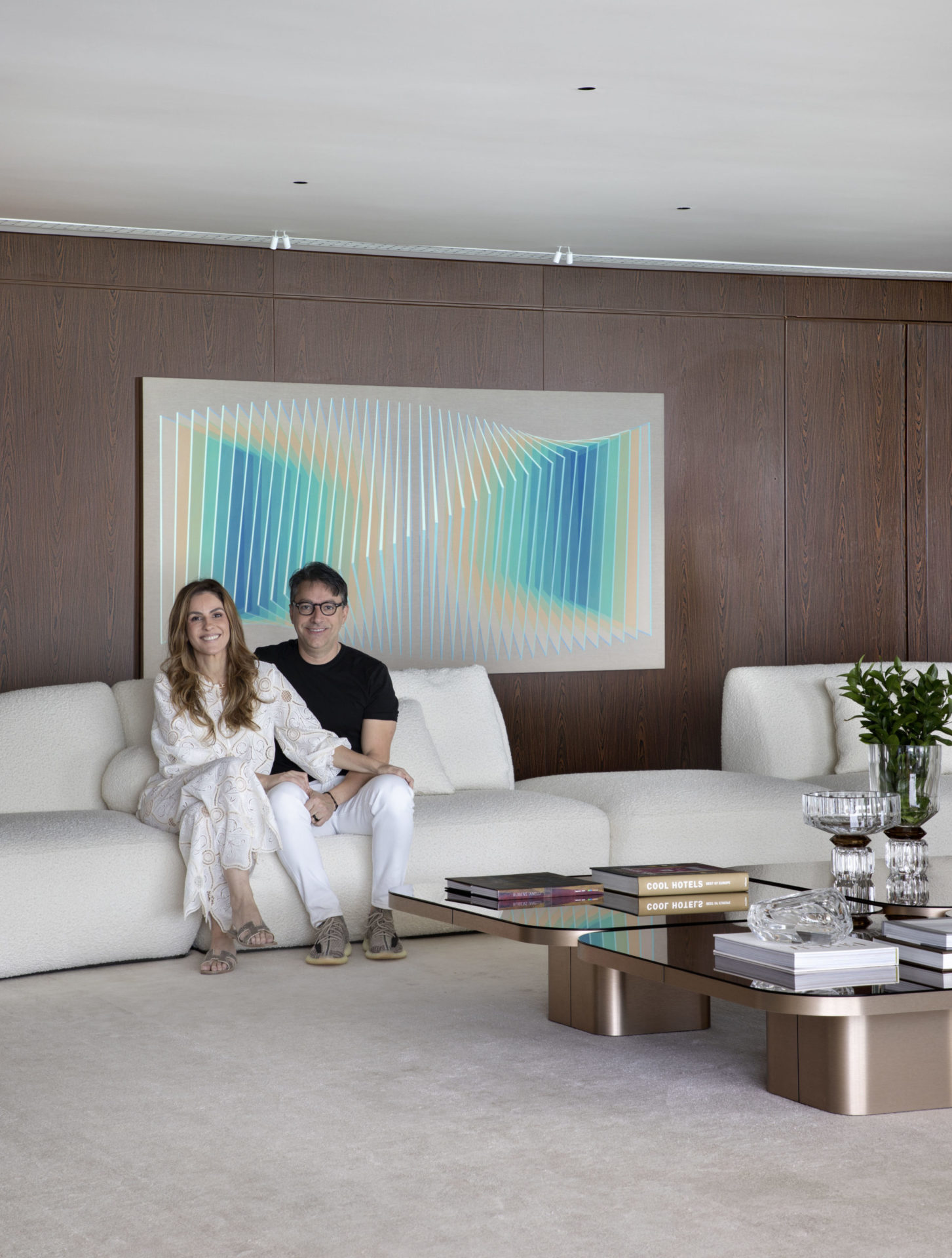 na foto um casal formado por uma mulher branca e um homem branco numa sala