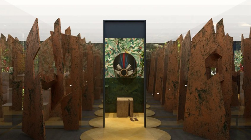 na foto esculturas e um cocar indígena