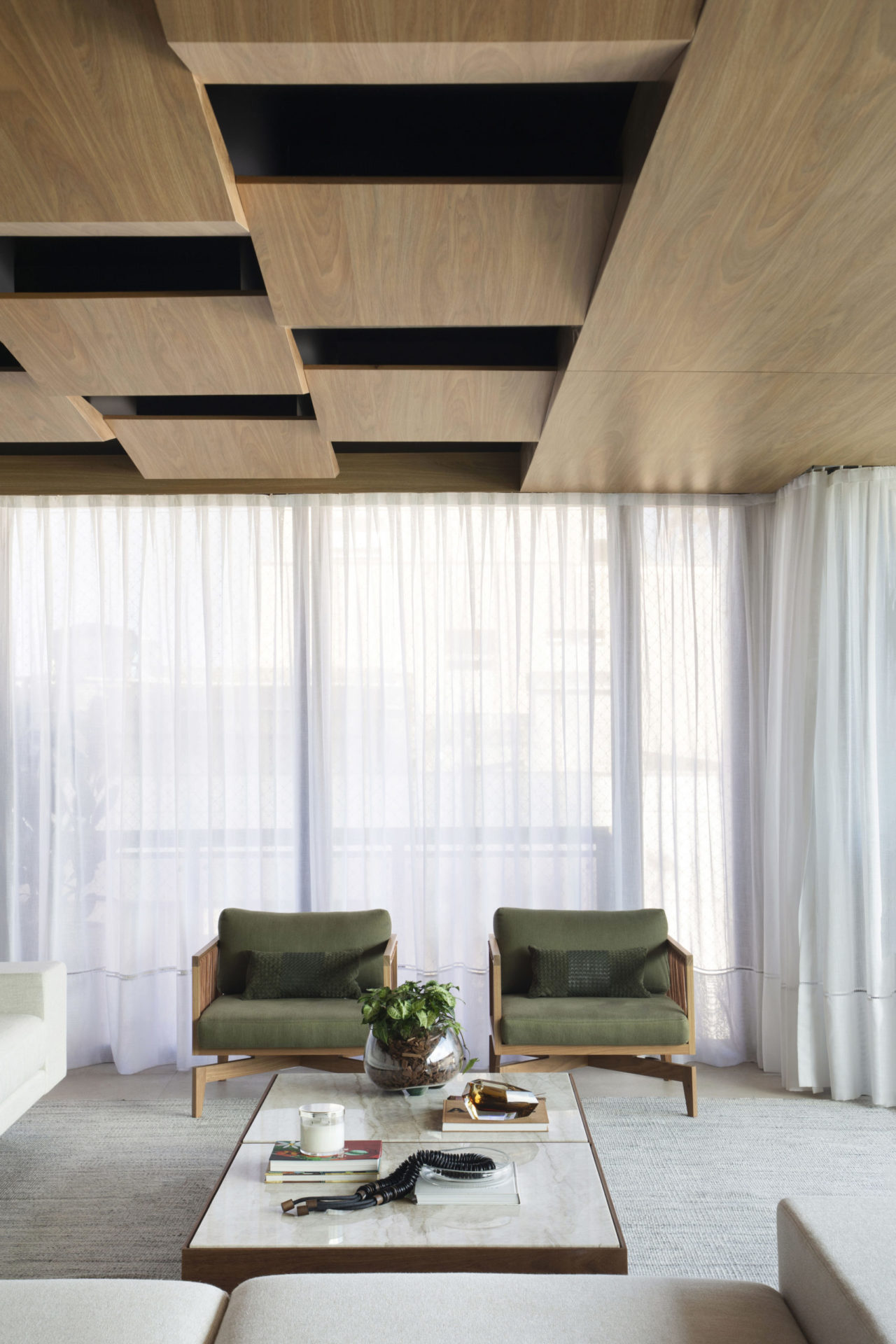 na foto duas poltronas em tecido verde e janelas grandes