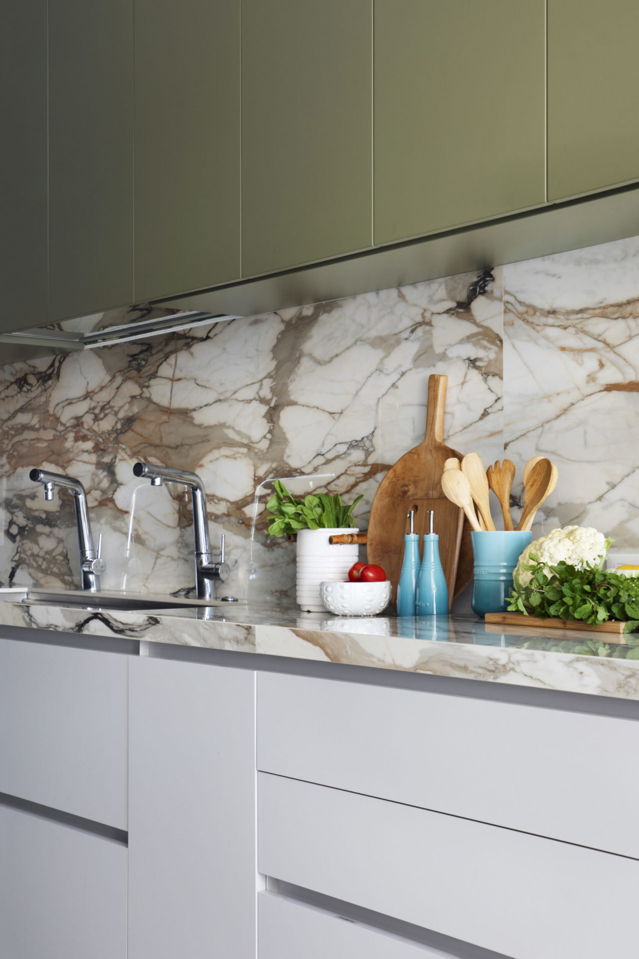 na foto cozinha com bancada e parede marmorizada