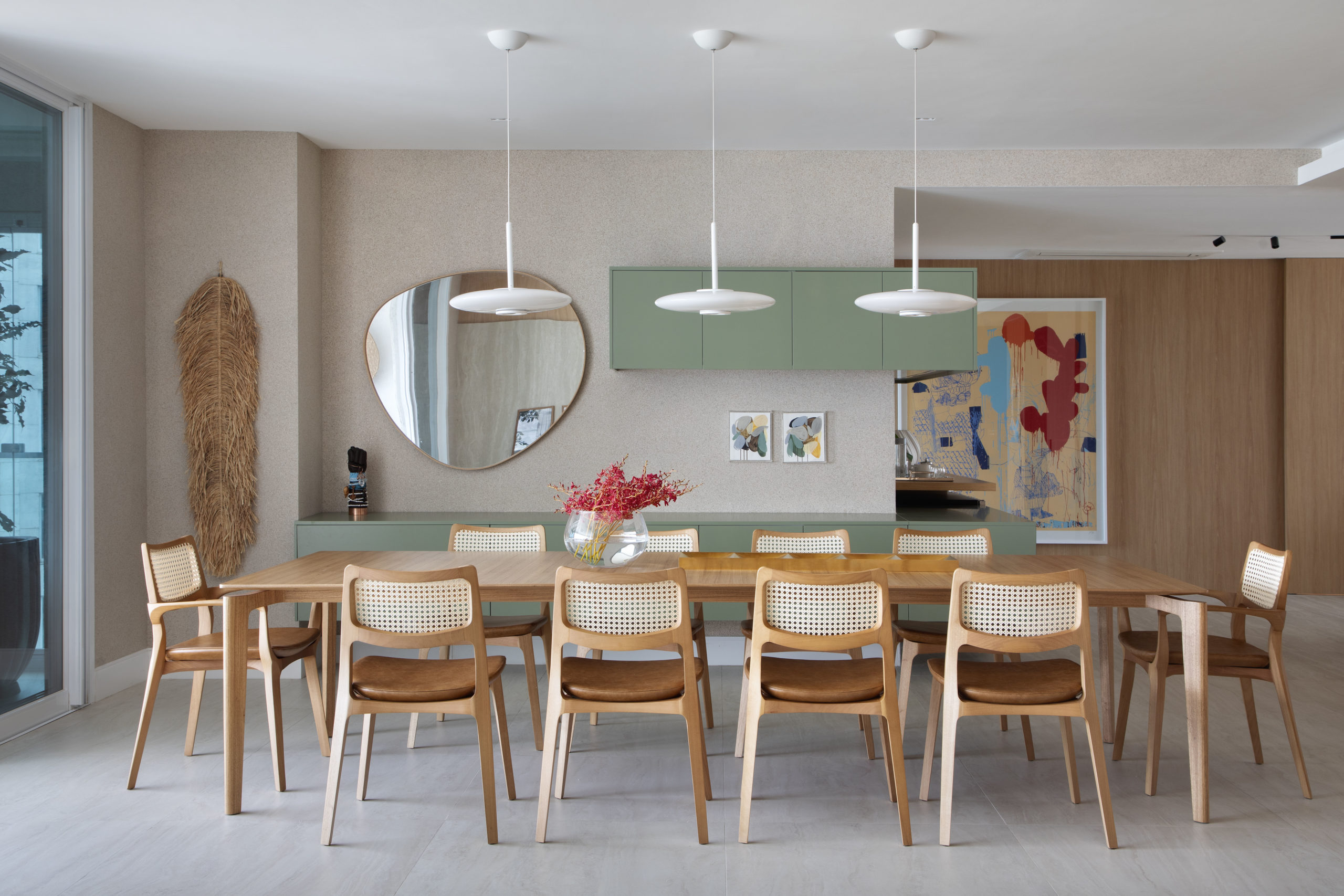 na foto mesa de jantar com vista para a cozinha e armários na cor verde