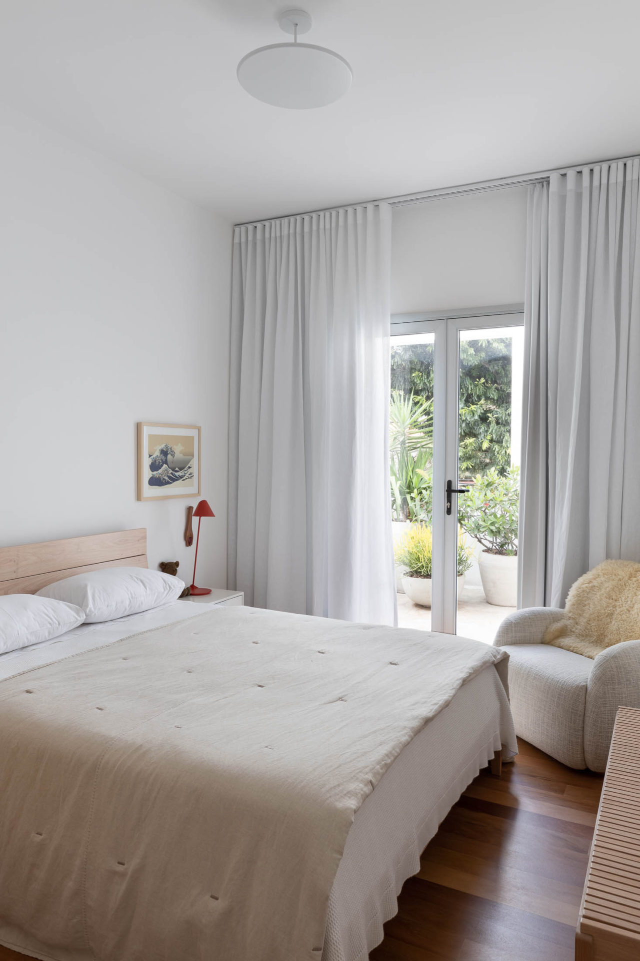 na foto quarto todo branco com porta pra varanda