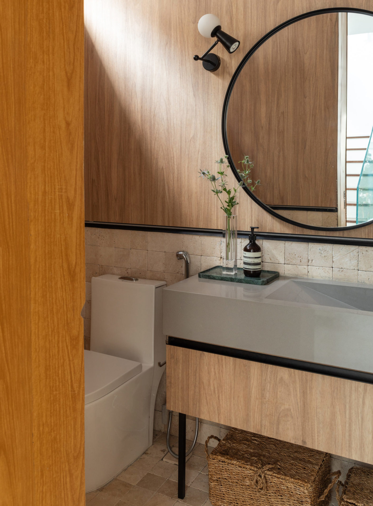 na foto banheiro com grande espelho redondo