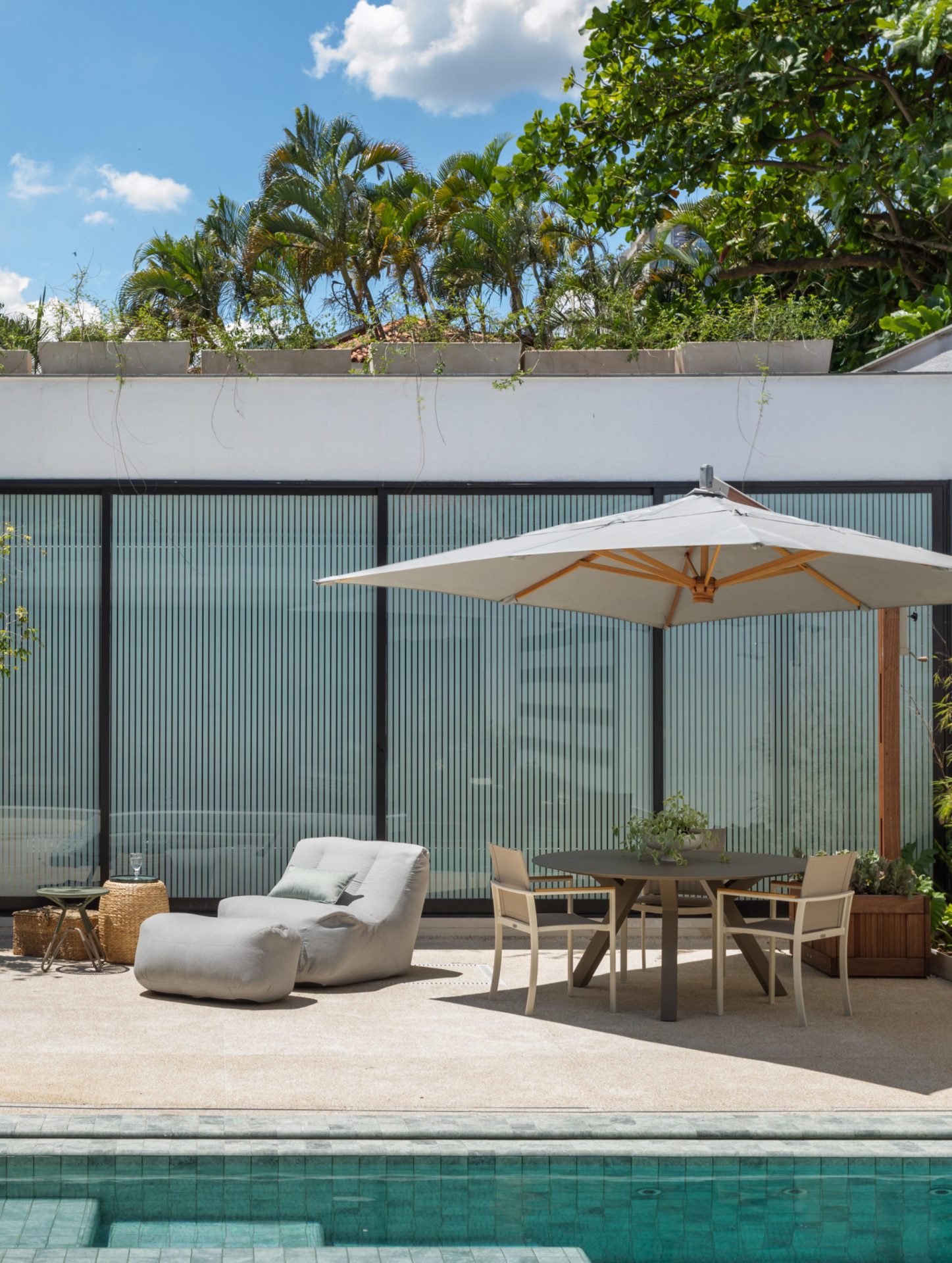 na foto casa com piscina, espreguiçadeira e ombrelone