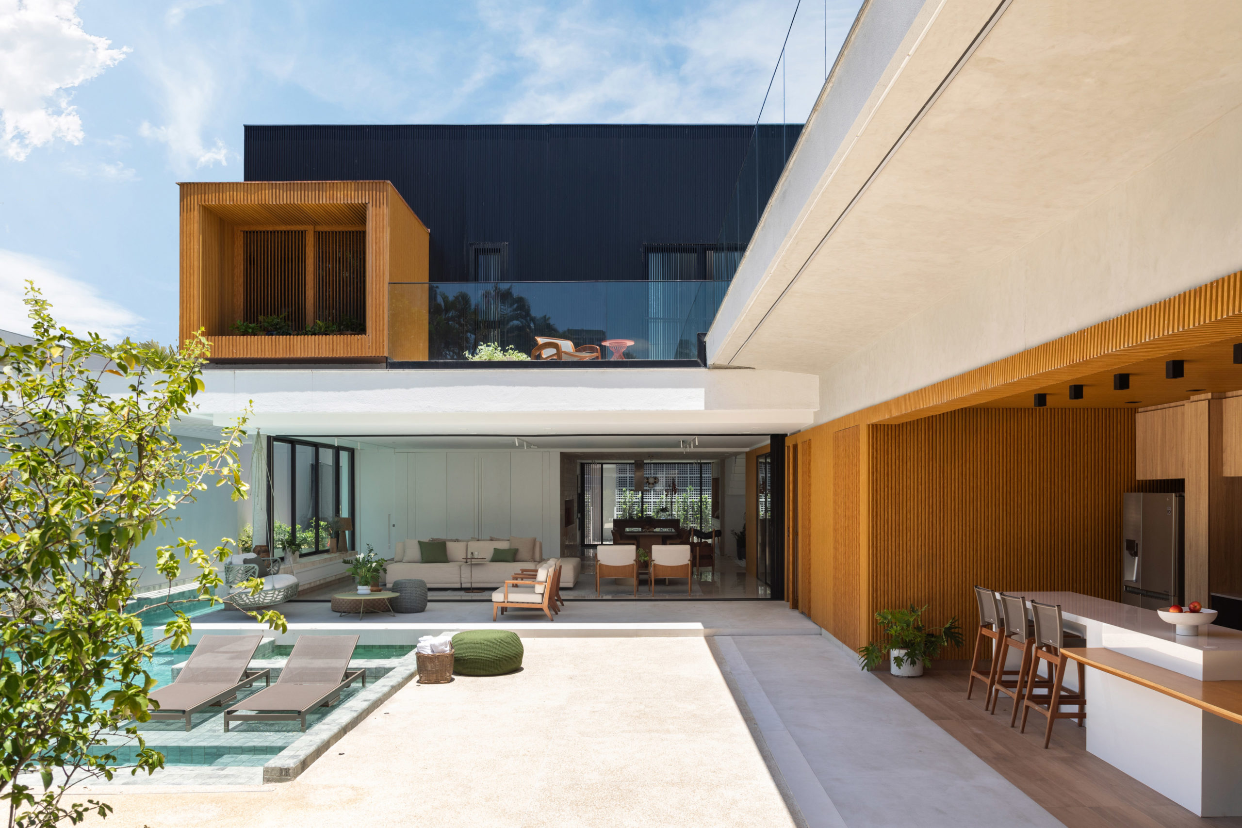 na foto área externa de casa na praia da Barra da Tijuca com três andares, varanda e piscina