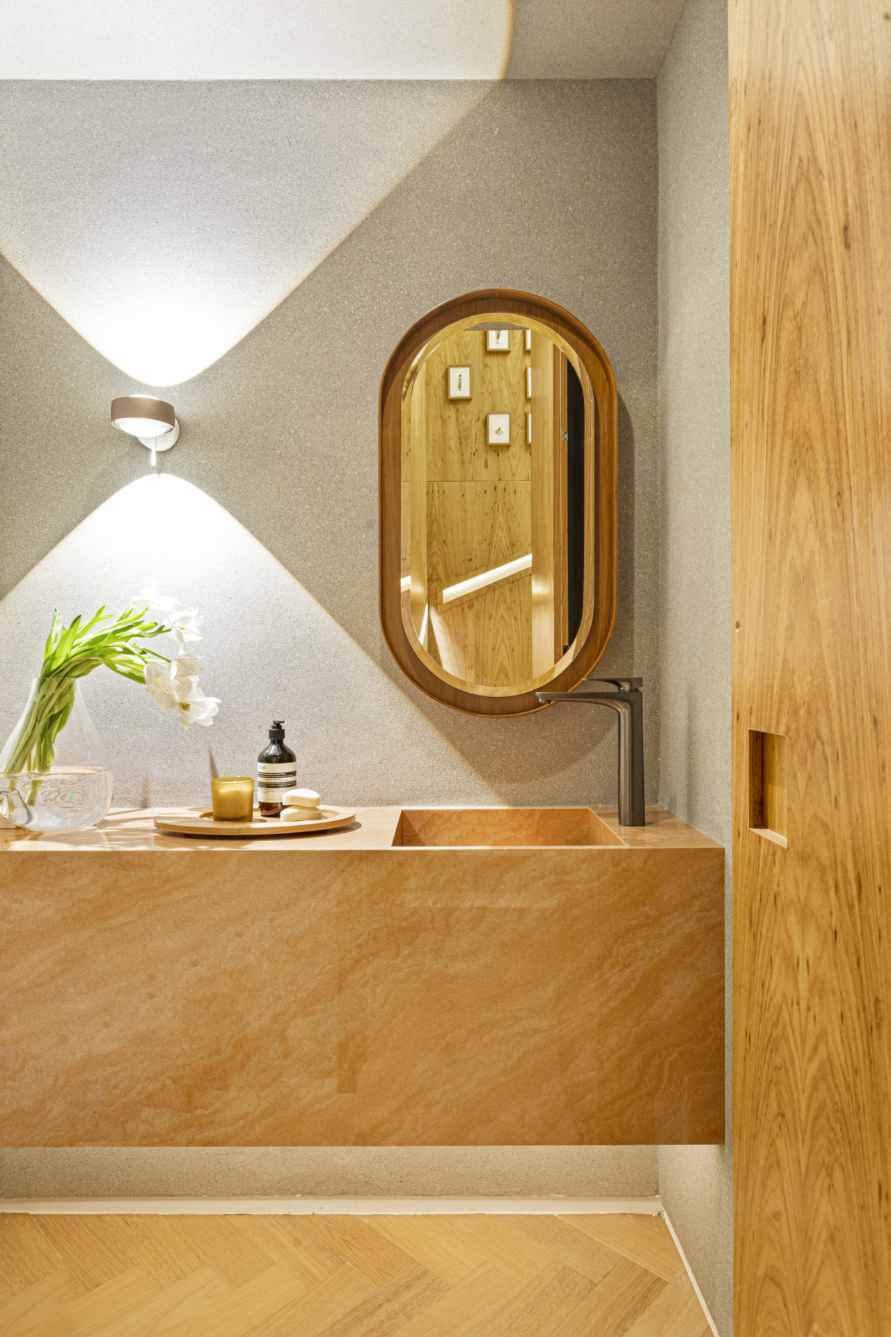 na foto lavabo com armário e porta em madeira clara