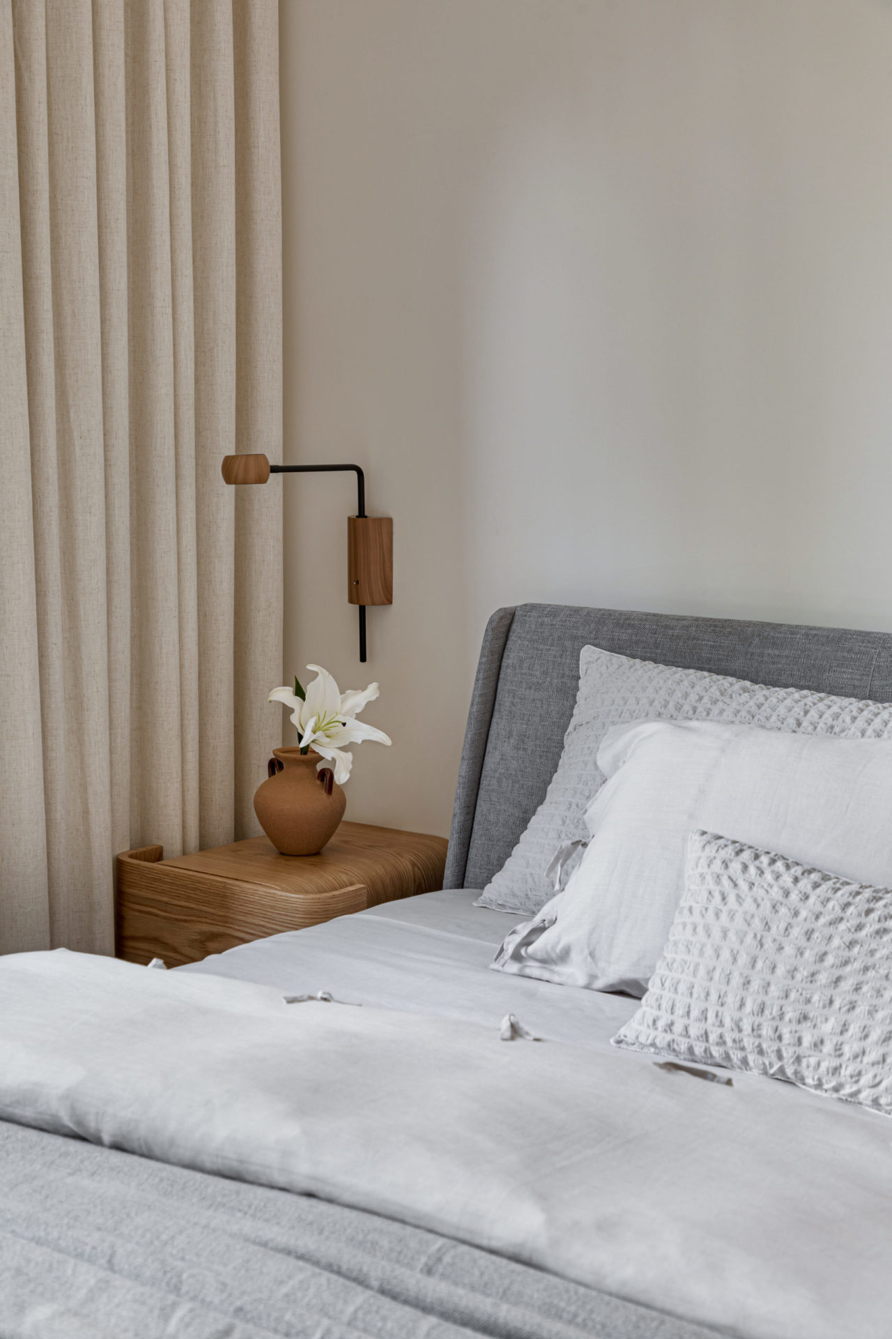na foto quarto com cama de casal, mesa de cabeceira e luminária