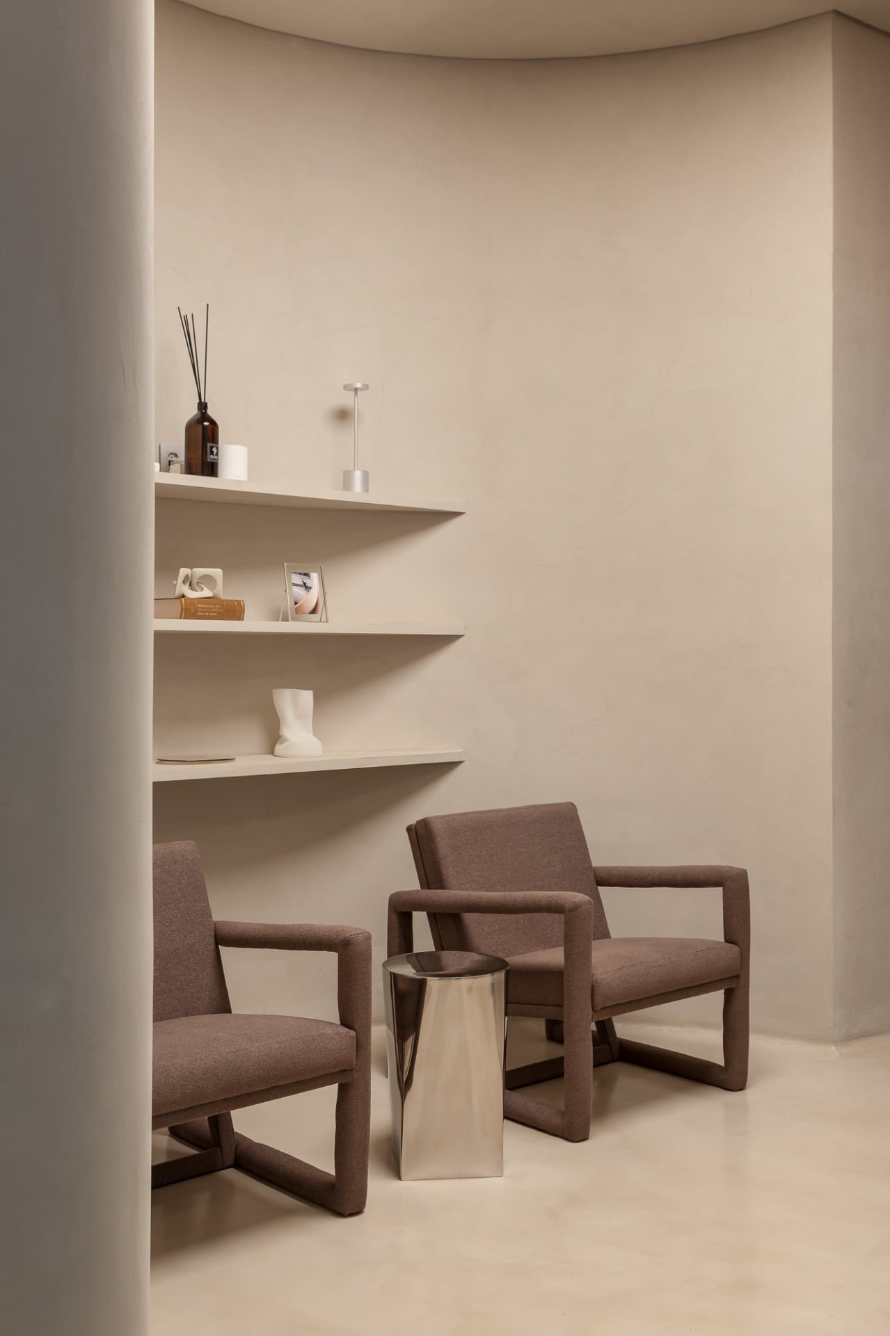 na foto espaço com duas cadeiras e prateleiras na parede