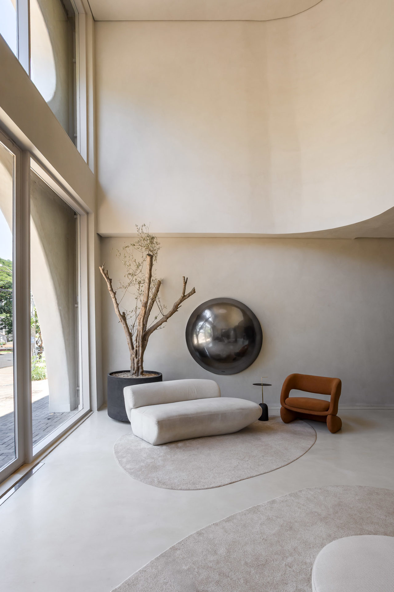 na foto recepção da Revive Clinic com sofá branco, poltrona de couro e portas grandes de vridro