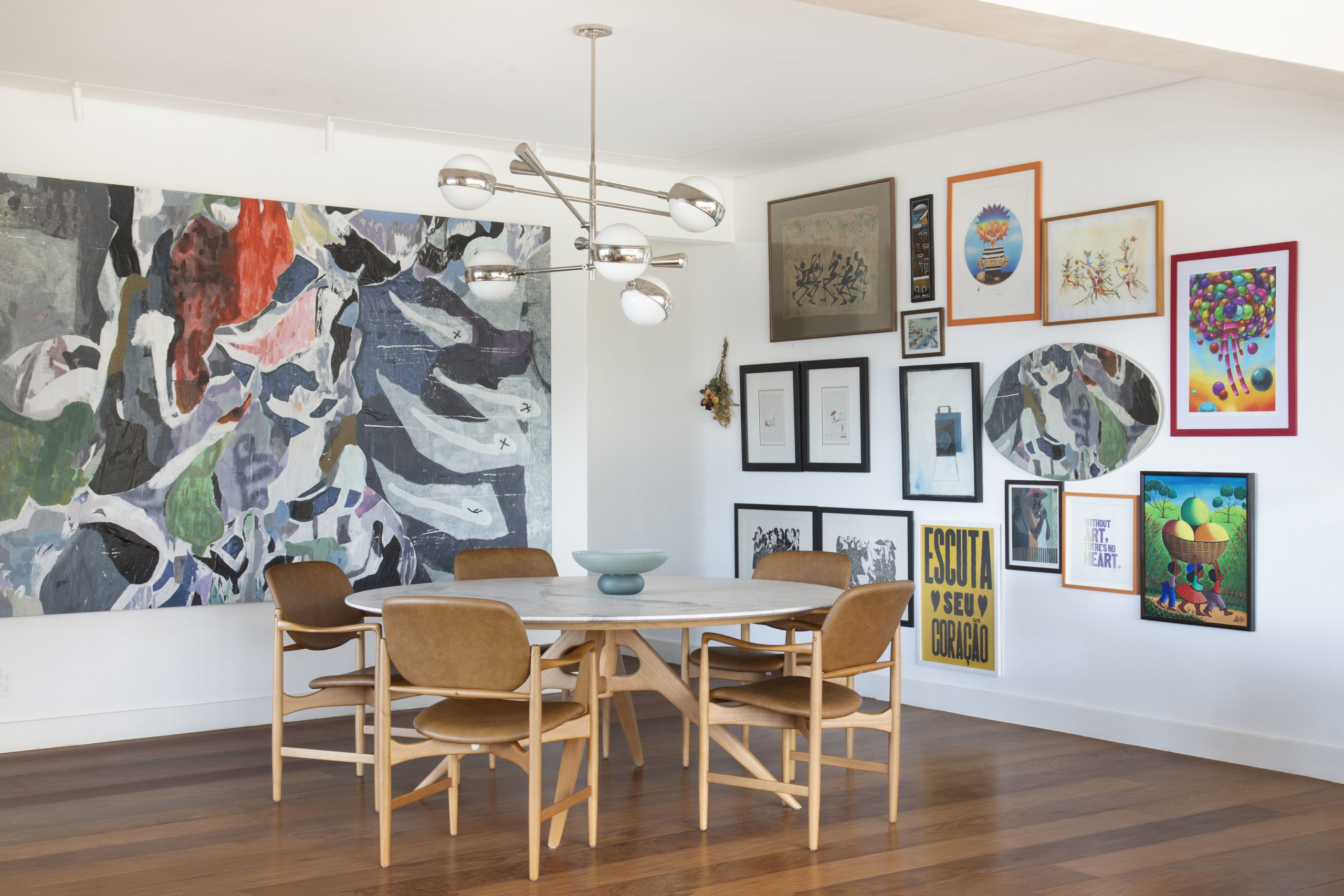 na foto sala de jantar com quadro colorido ocupando uma parede